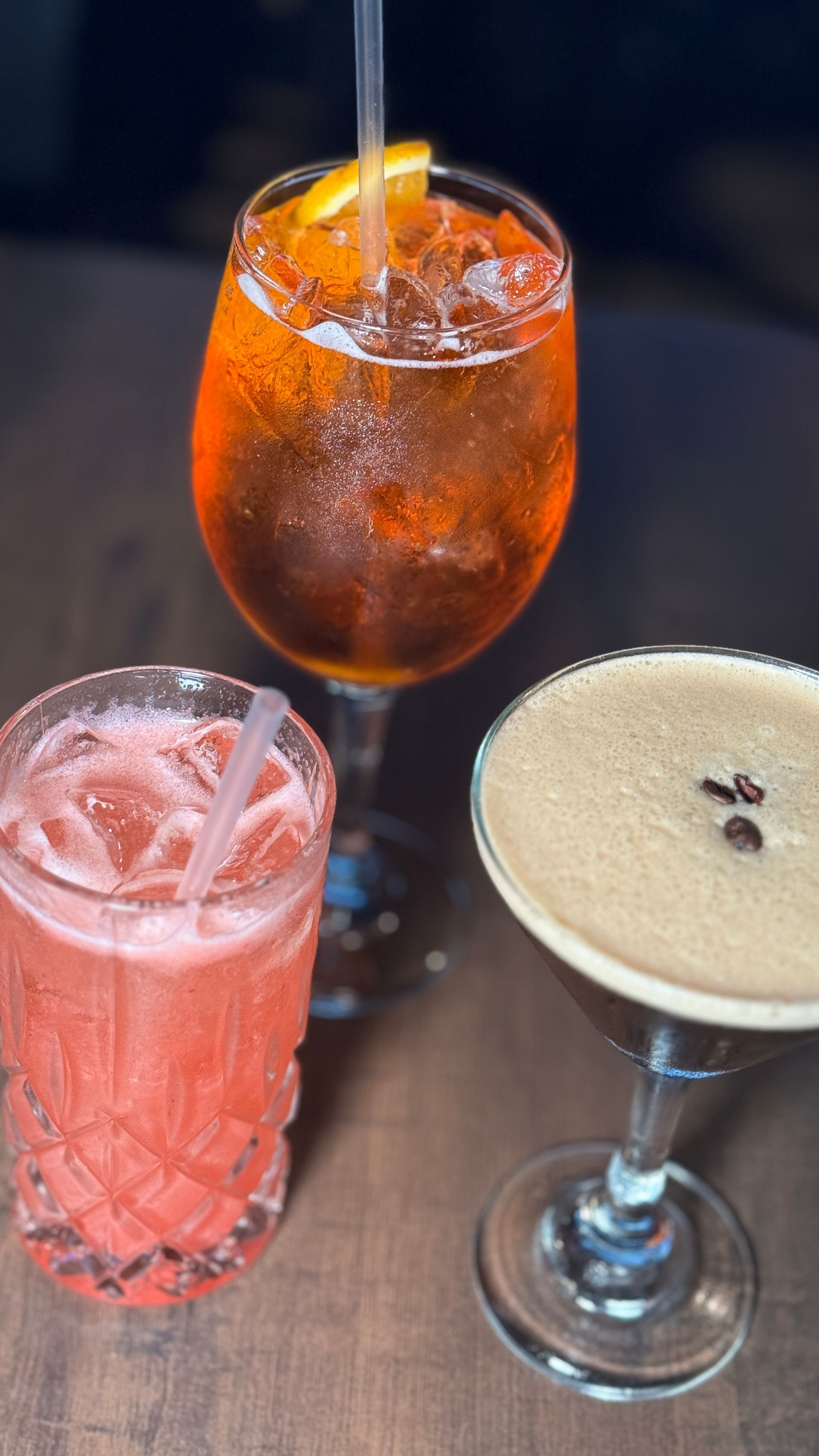 Three different types of drinks are sitting on a wooden table.