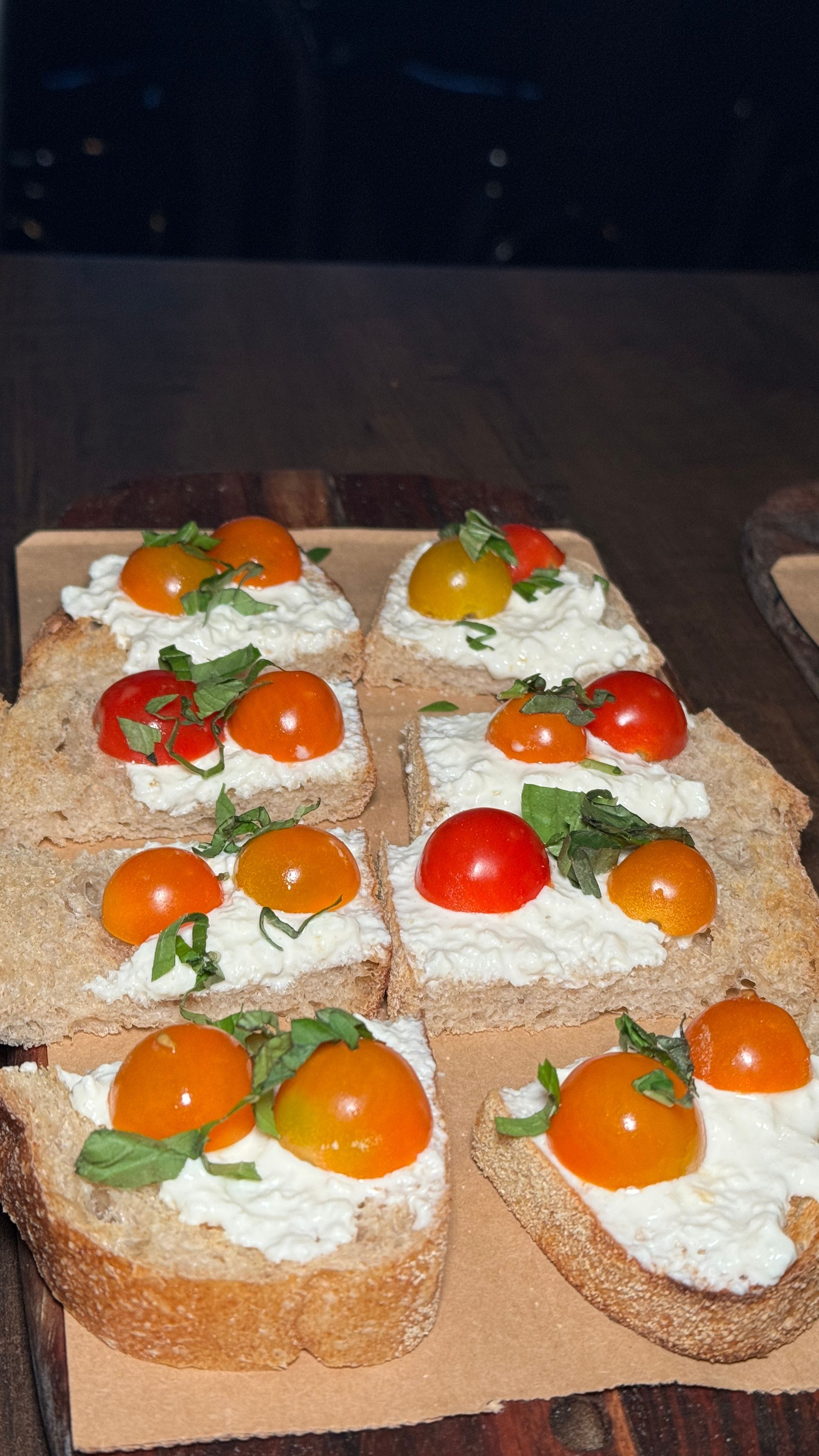 A bunch of sandwiches with tomatoes and cheese on them