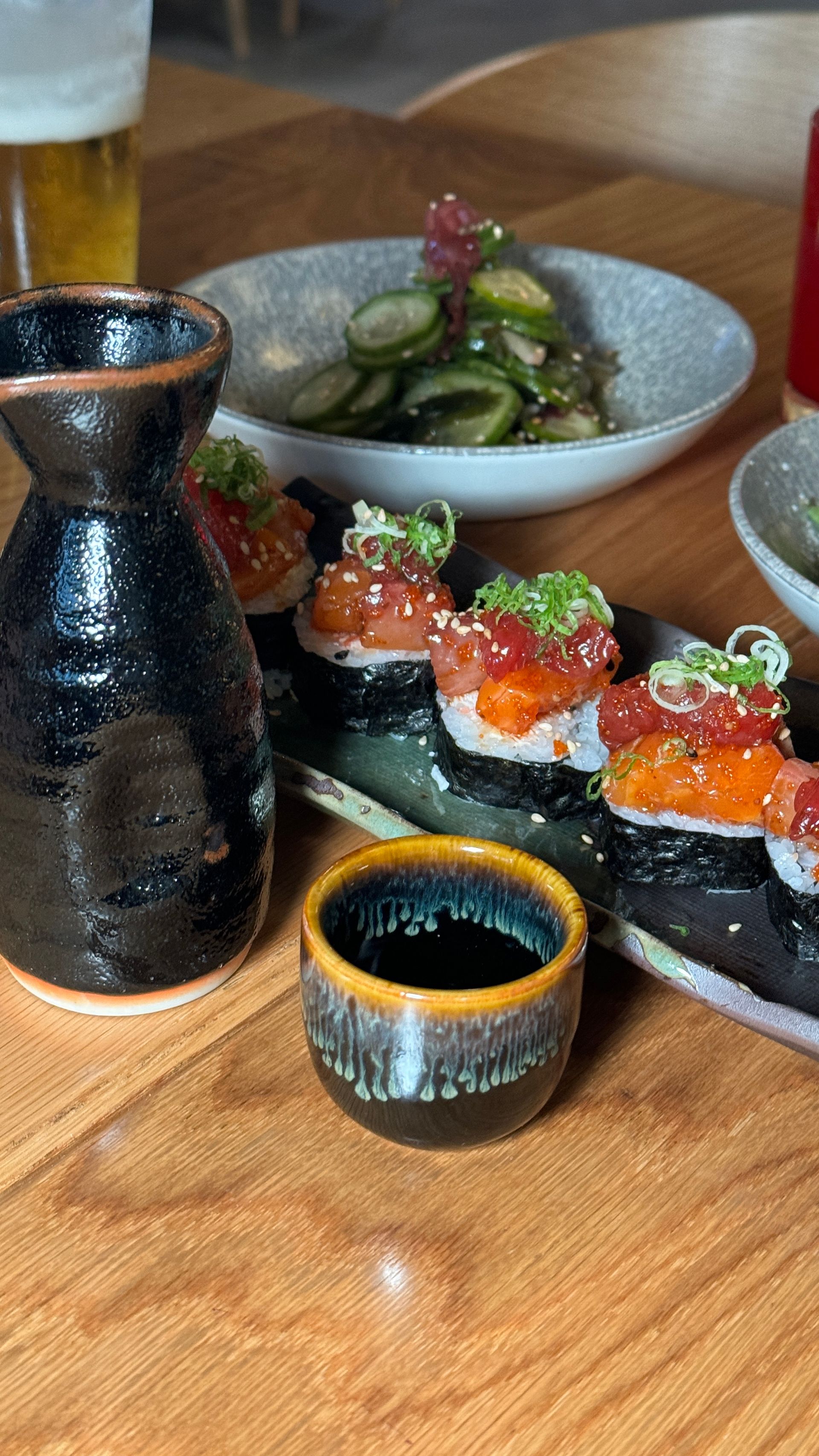 A table topped with plates of food and a glass of beer.