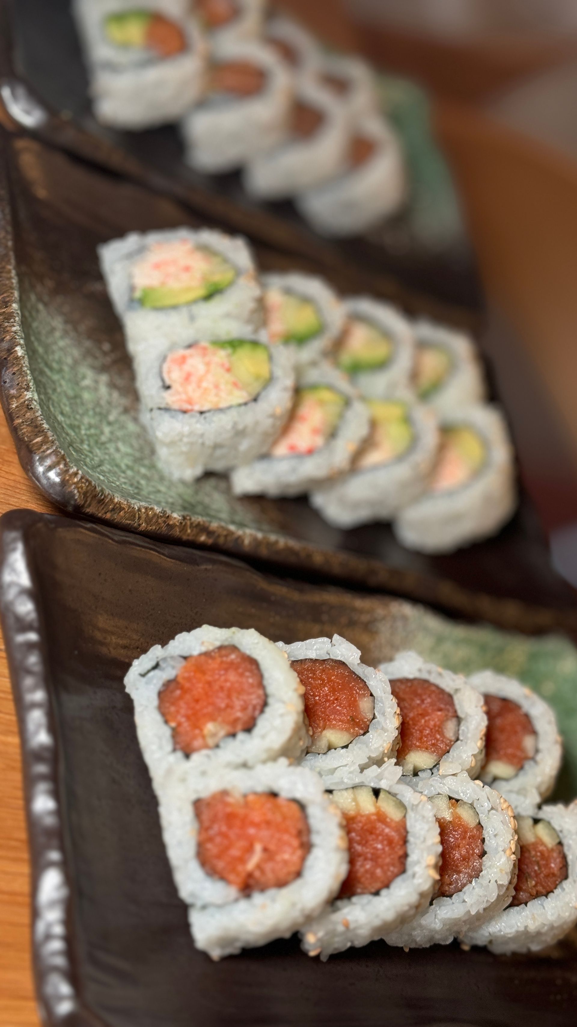 Two plates of sushi are lined up on a table.