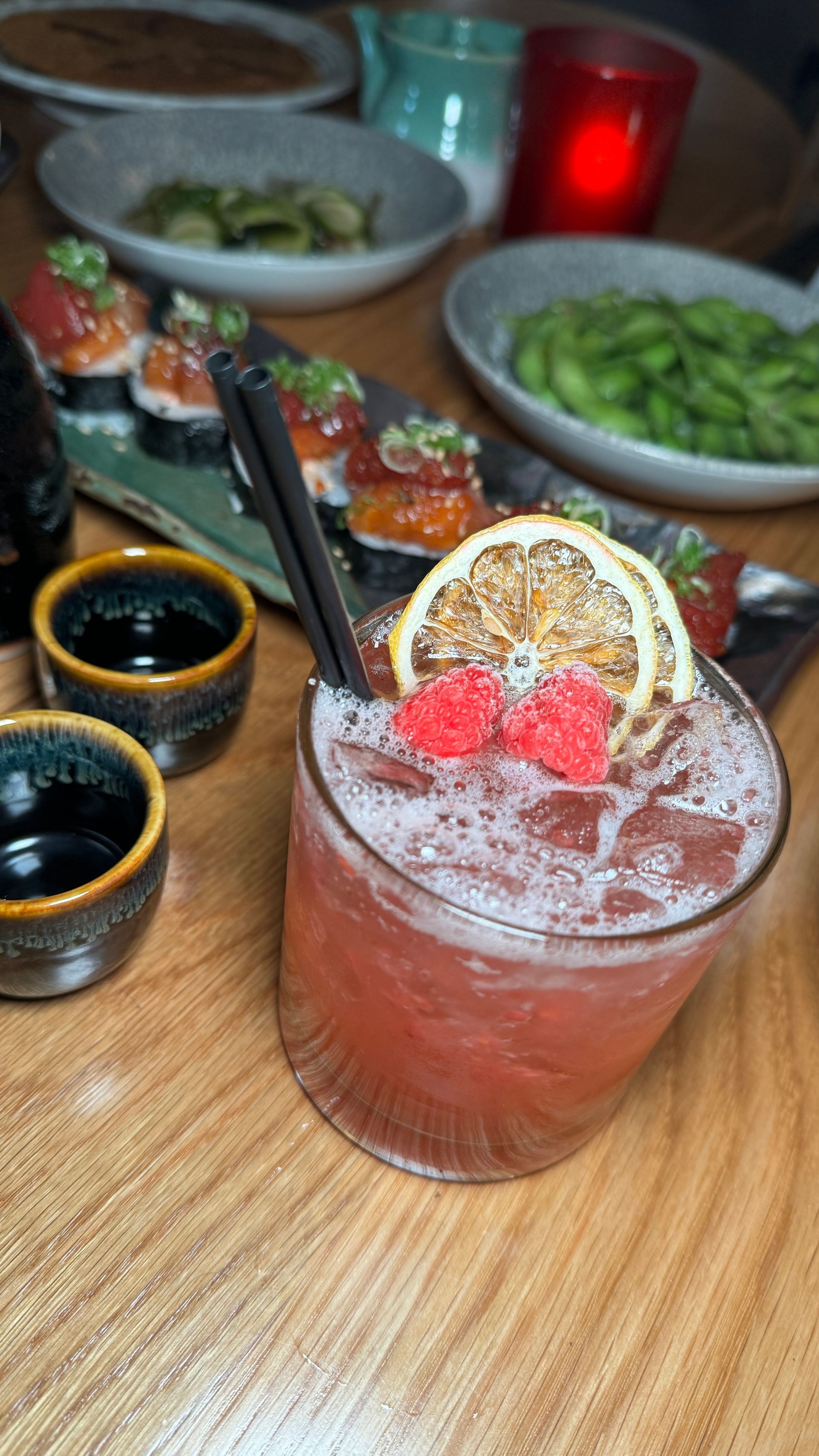 A close up of a drink on a table with food in the background.