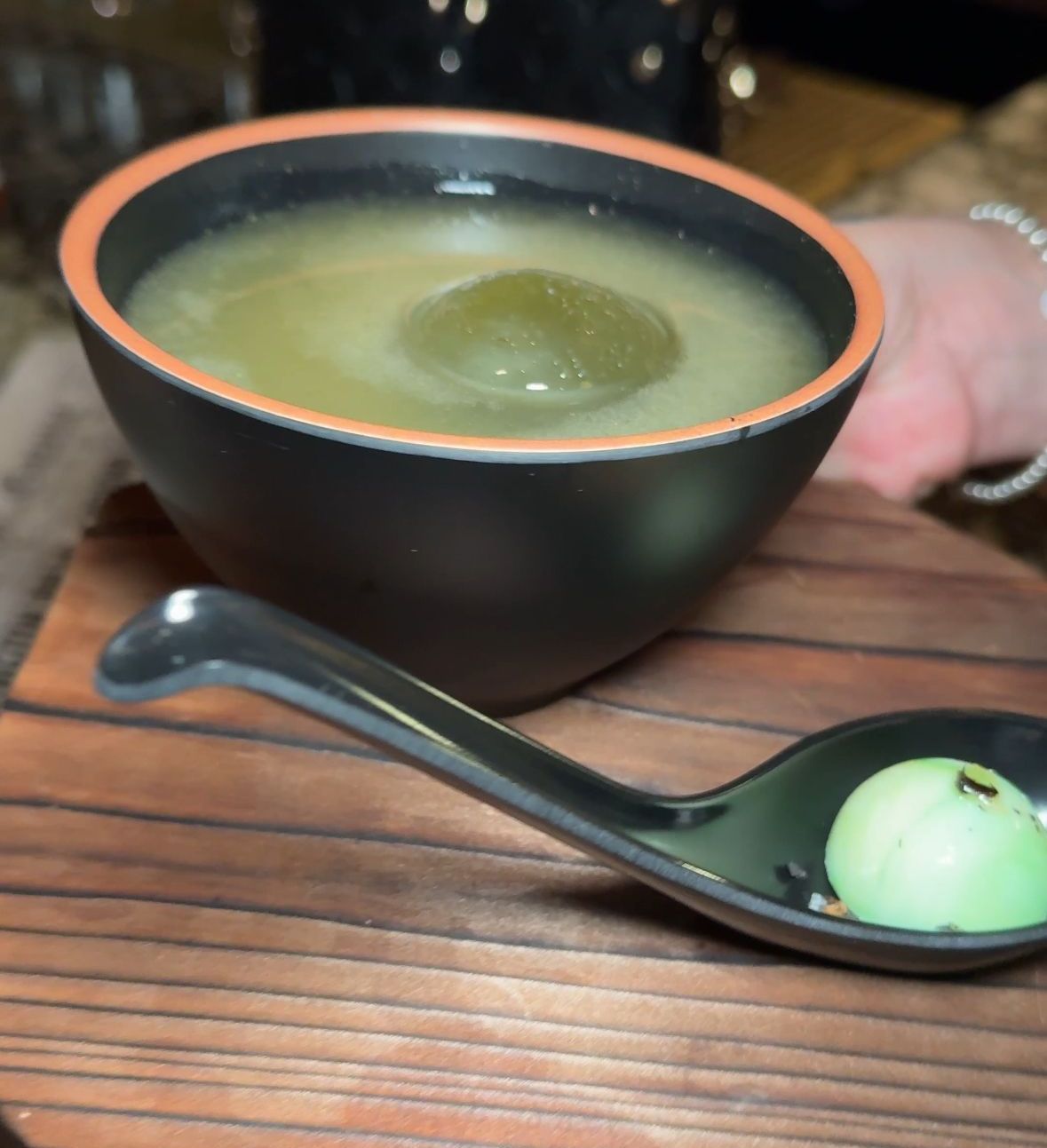 A bowl of soup next to a spoon with the number 1 on it