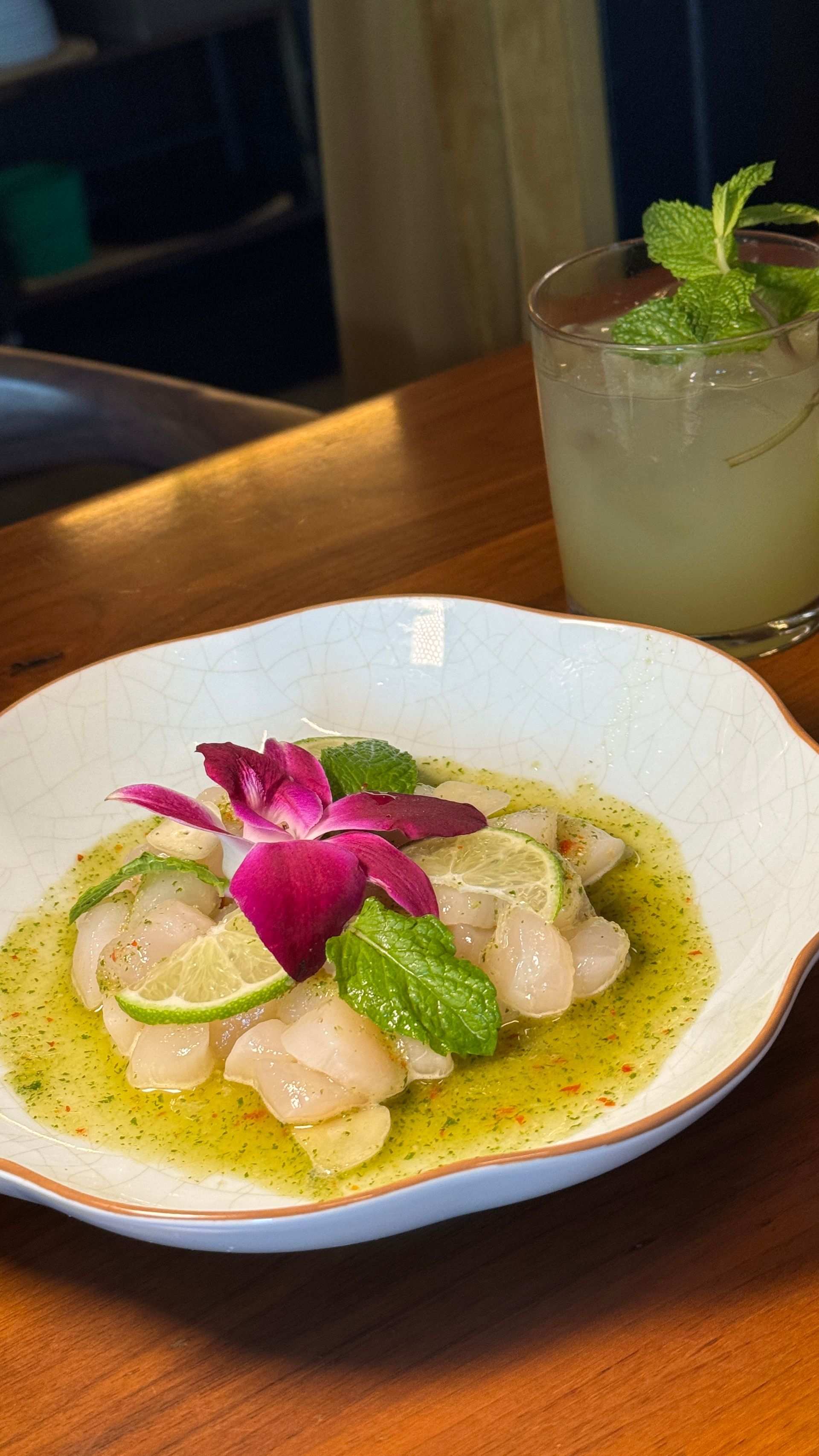 A plate of food and a drink on a wooden table.