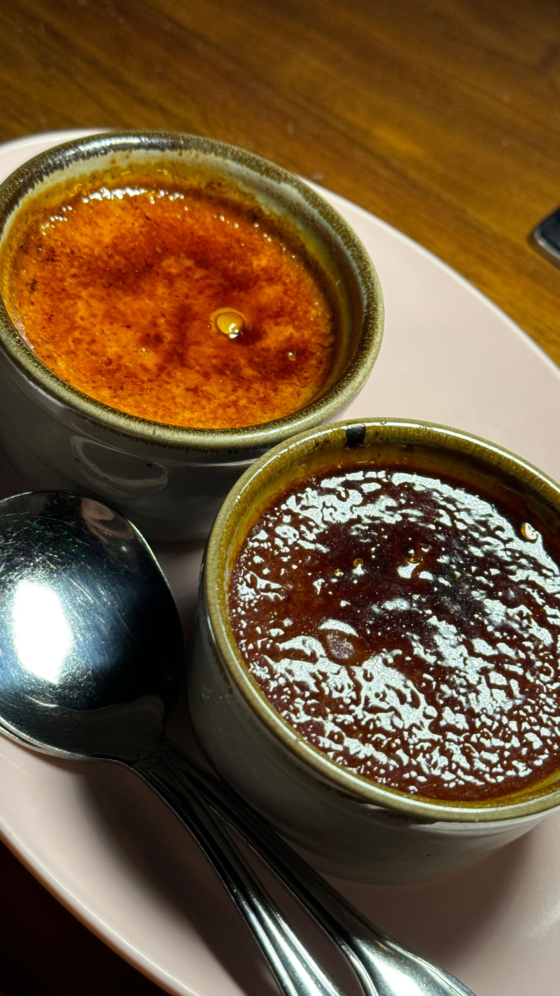 Two bowls of food on a plate with a spoon