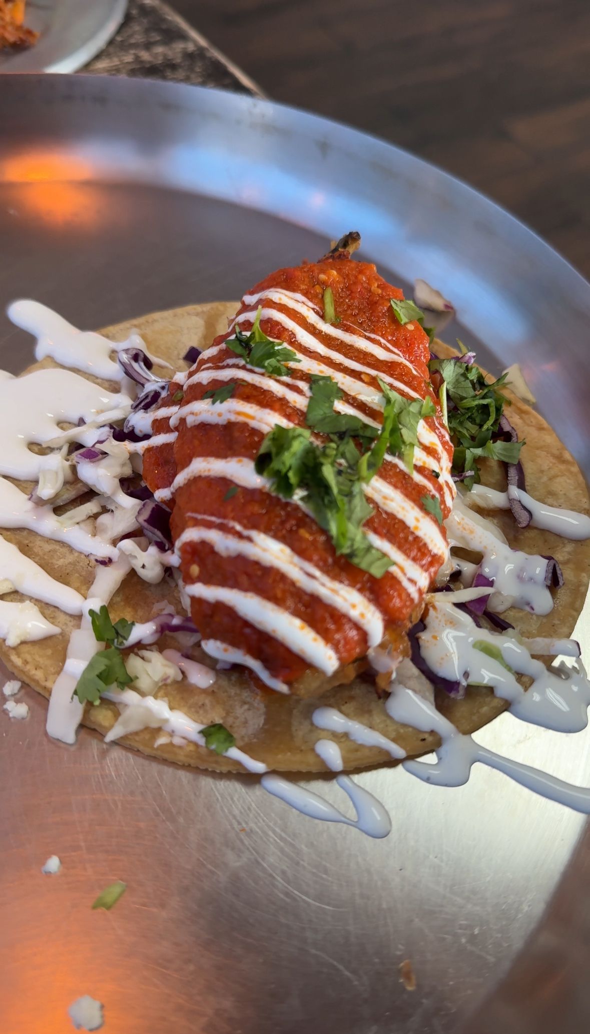 A close up of a taco on a plate on a table.