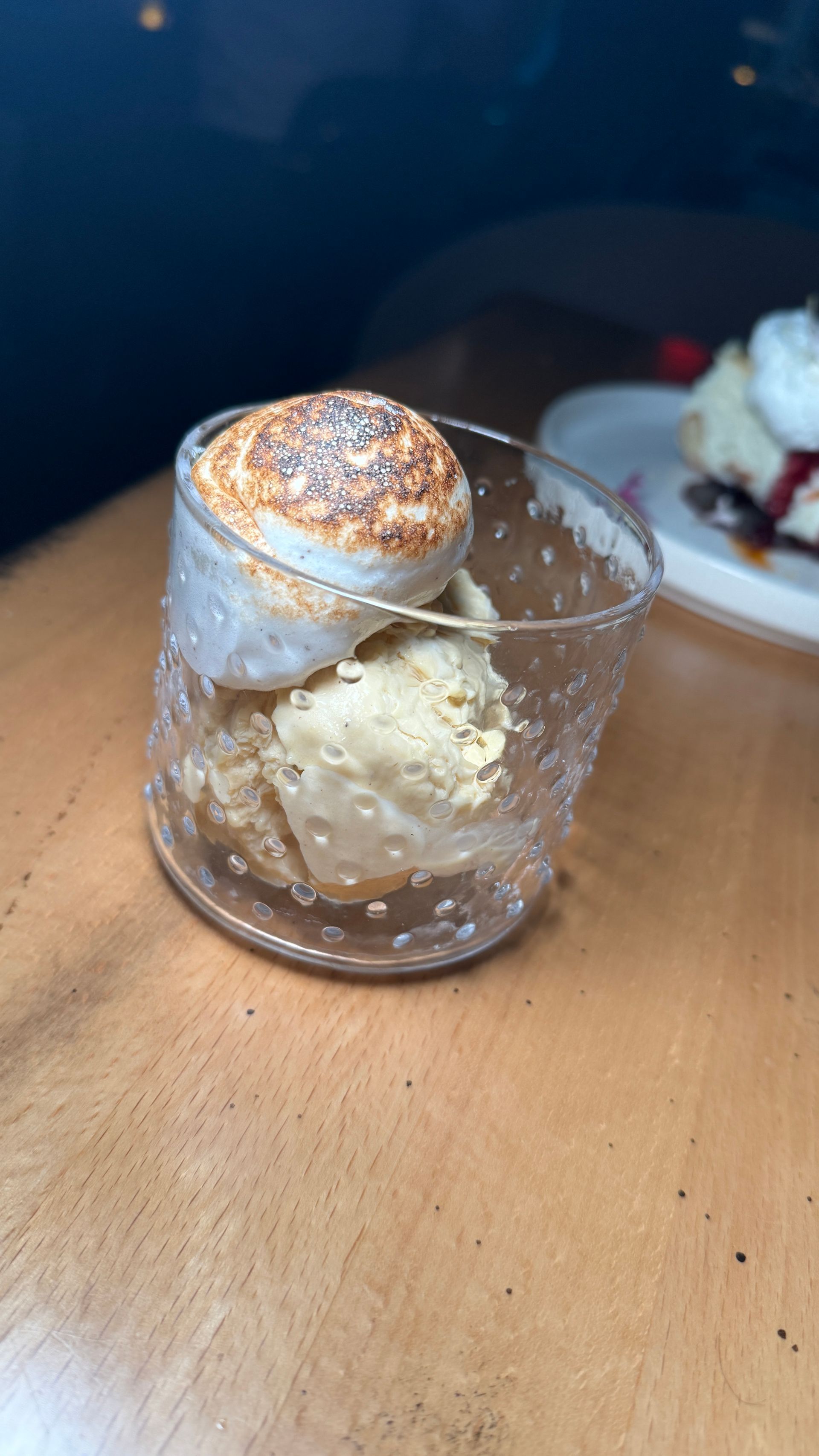 A close up of a dessert in a glass on a table.