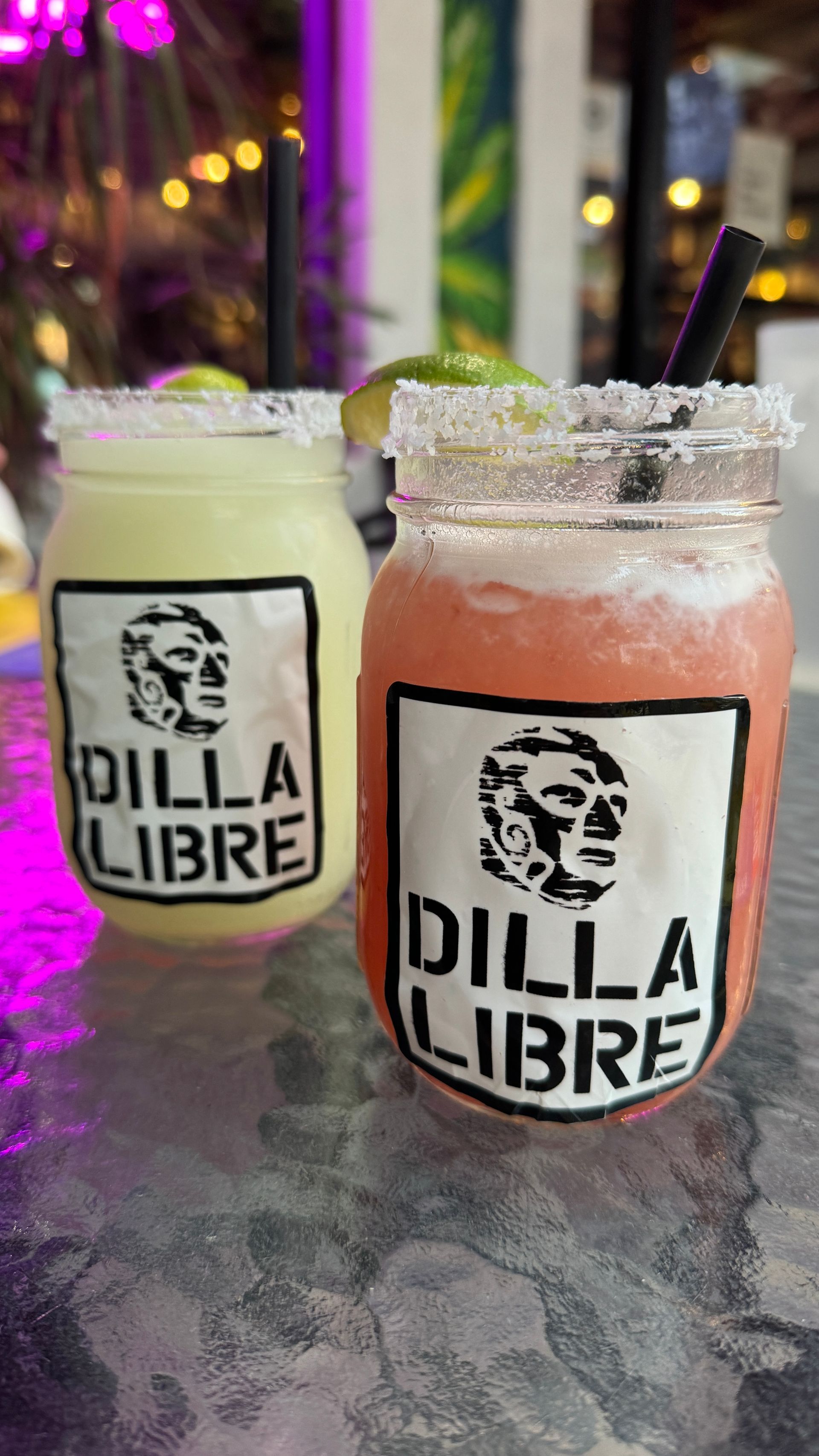 Two bottles of dilla libre drinks are sitting on a table.