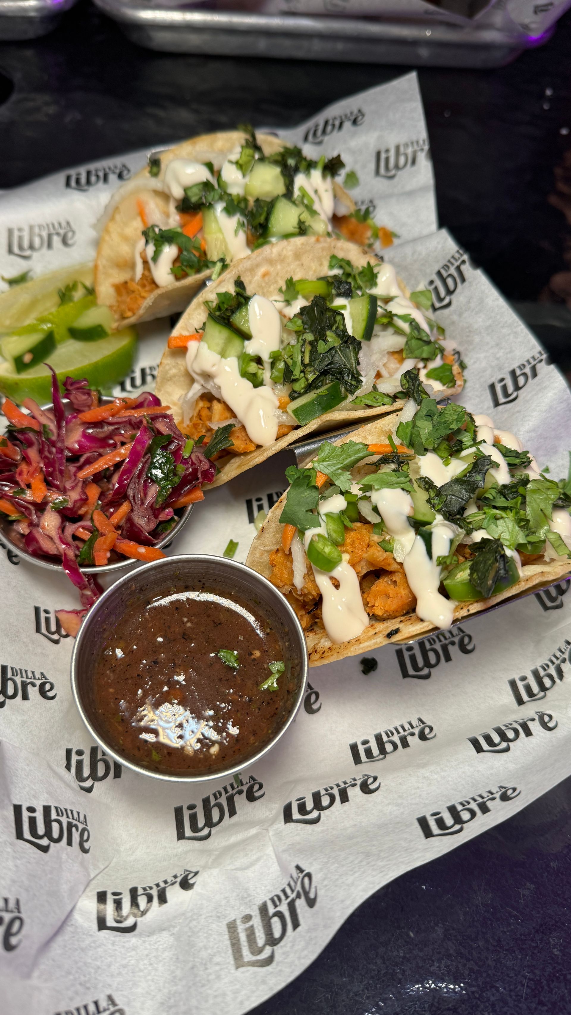 A close up of a plate of food on a table with a bowl of sauce.