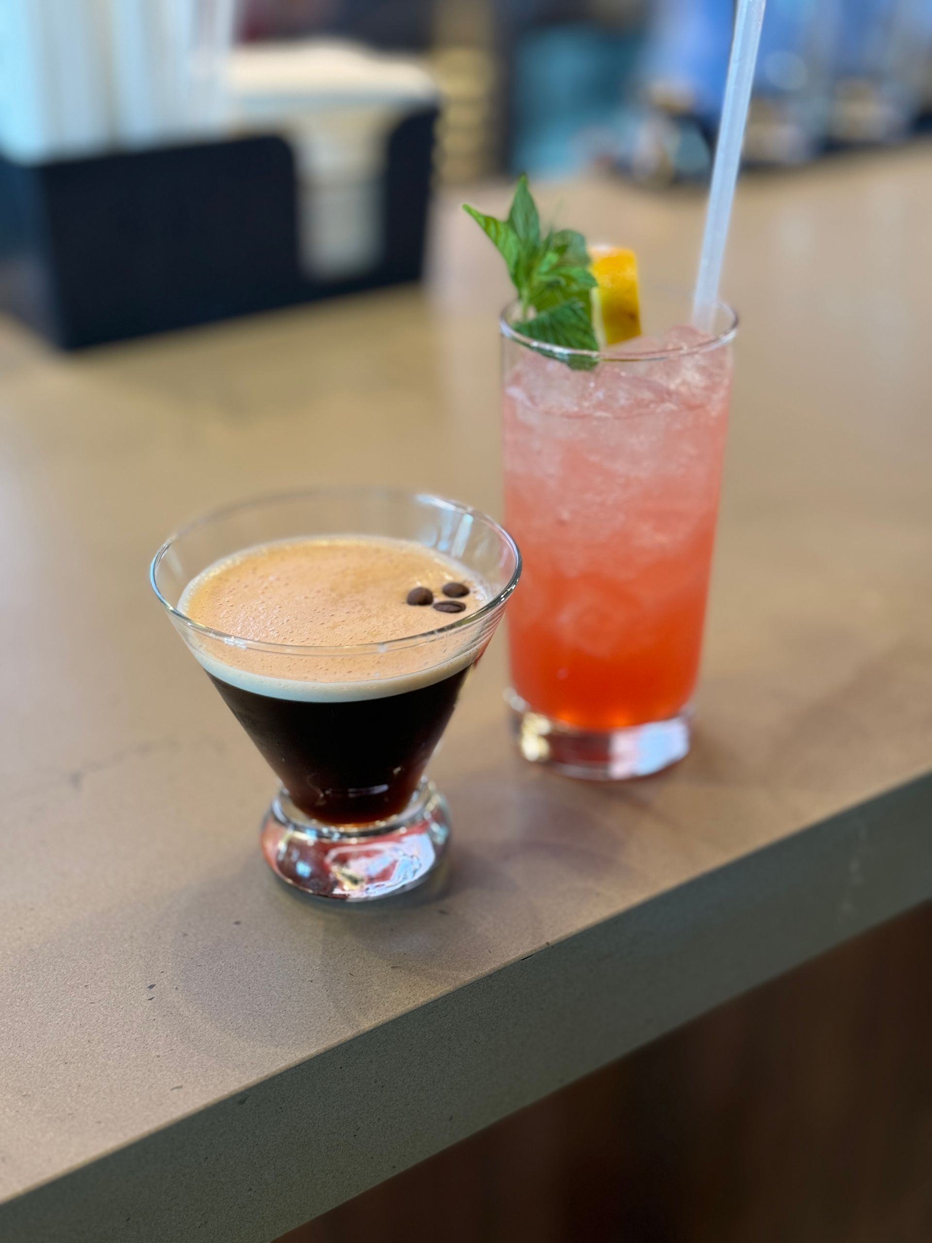 A martini and a pink drink are on a table