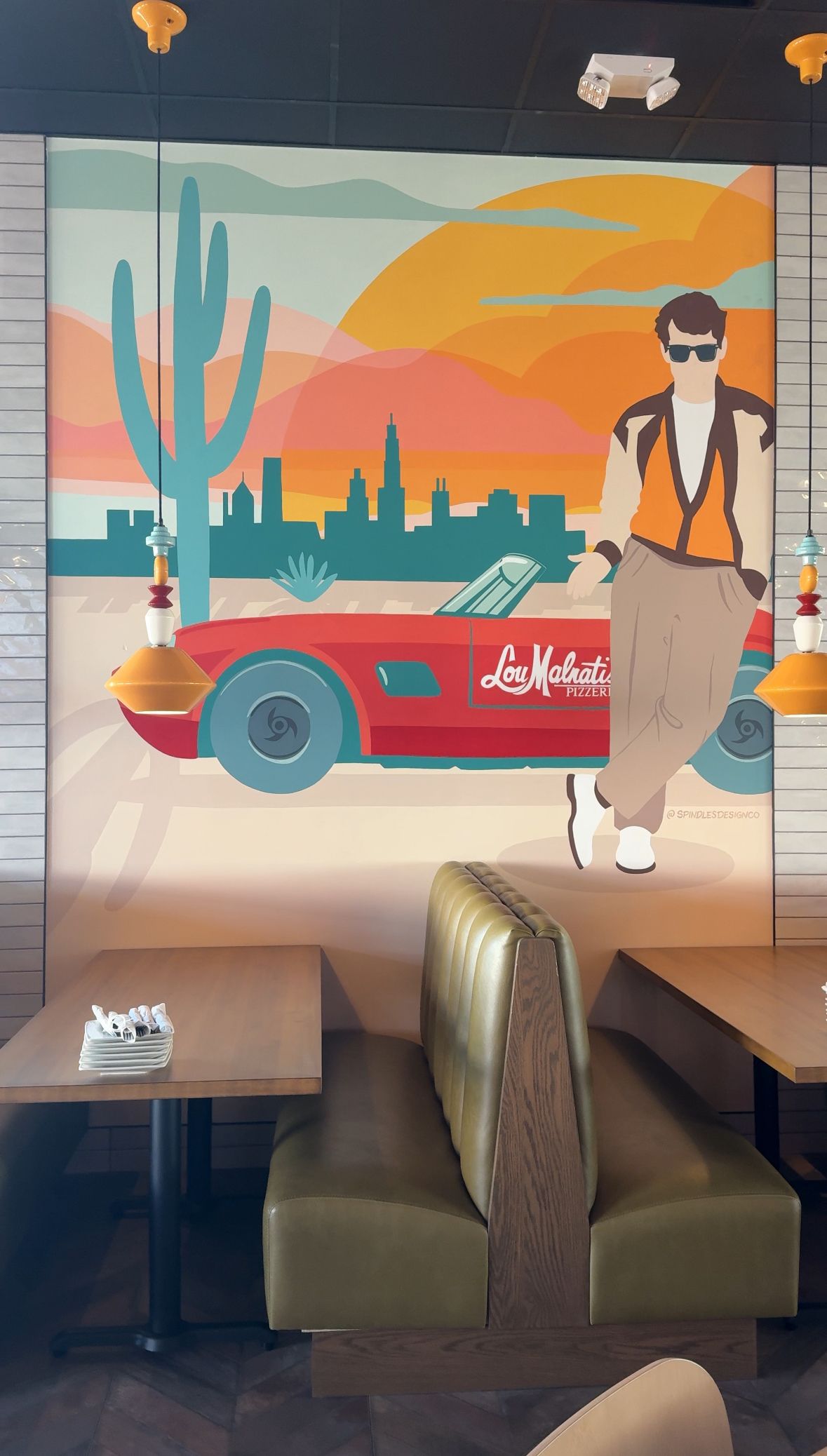 A painting of a man carrying a suitcase is on the wall of a restaurant.