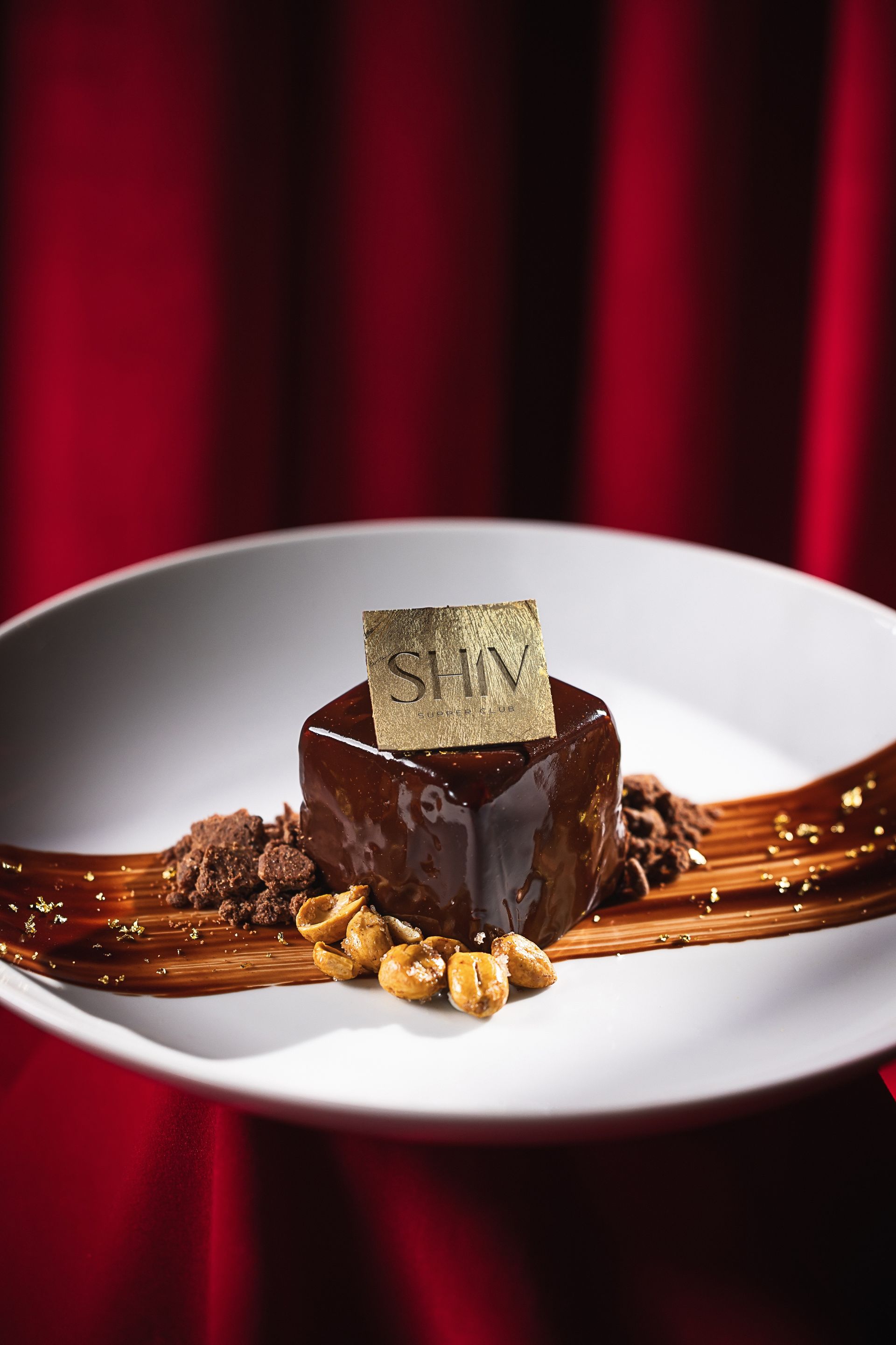 A white plate topped with a chocolate dessert and nuts.