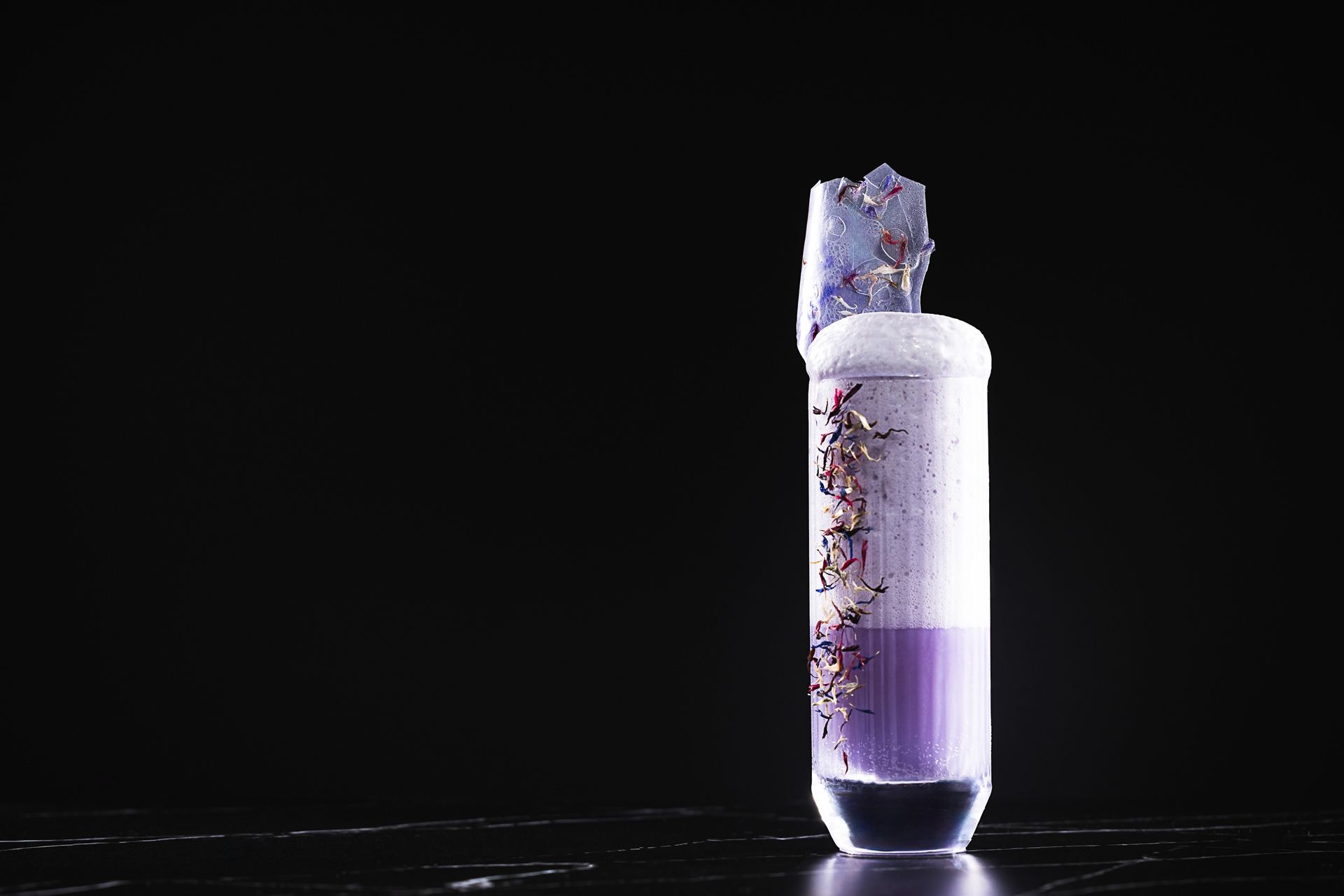 A test tube filled with purple liquid is sitting on a table.