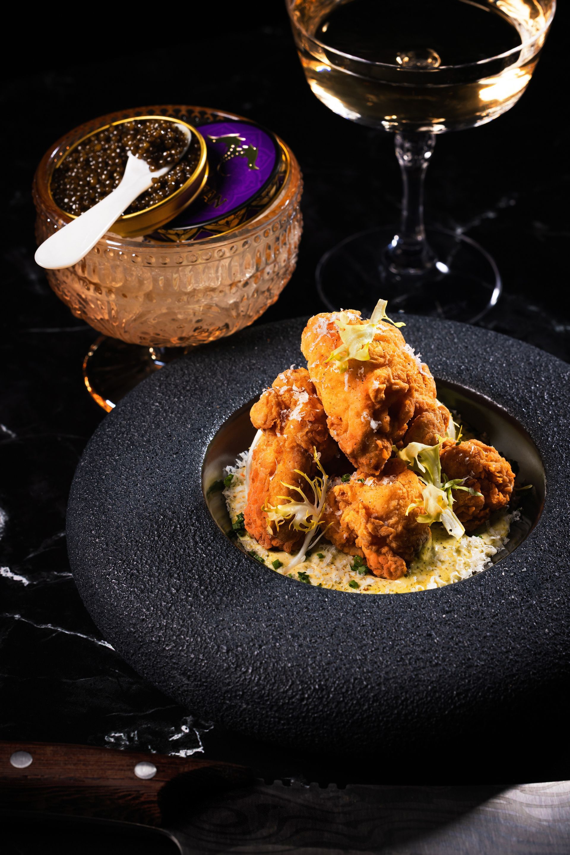 A plate of food and a glass of wine on a table.