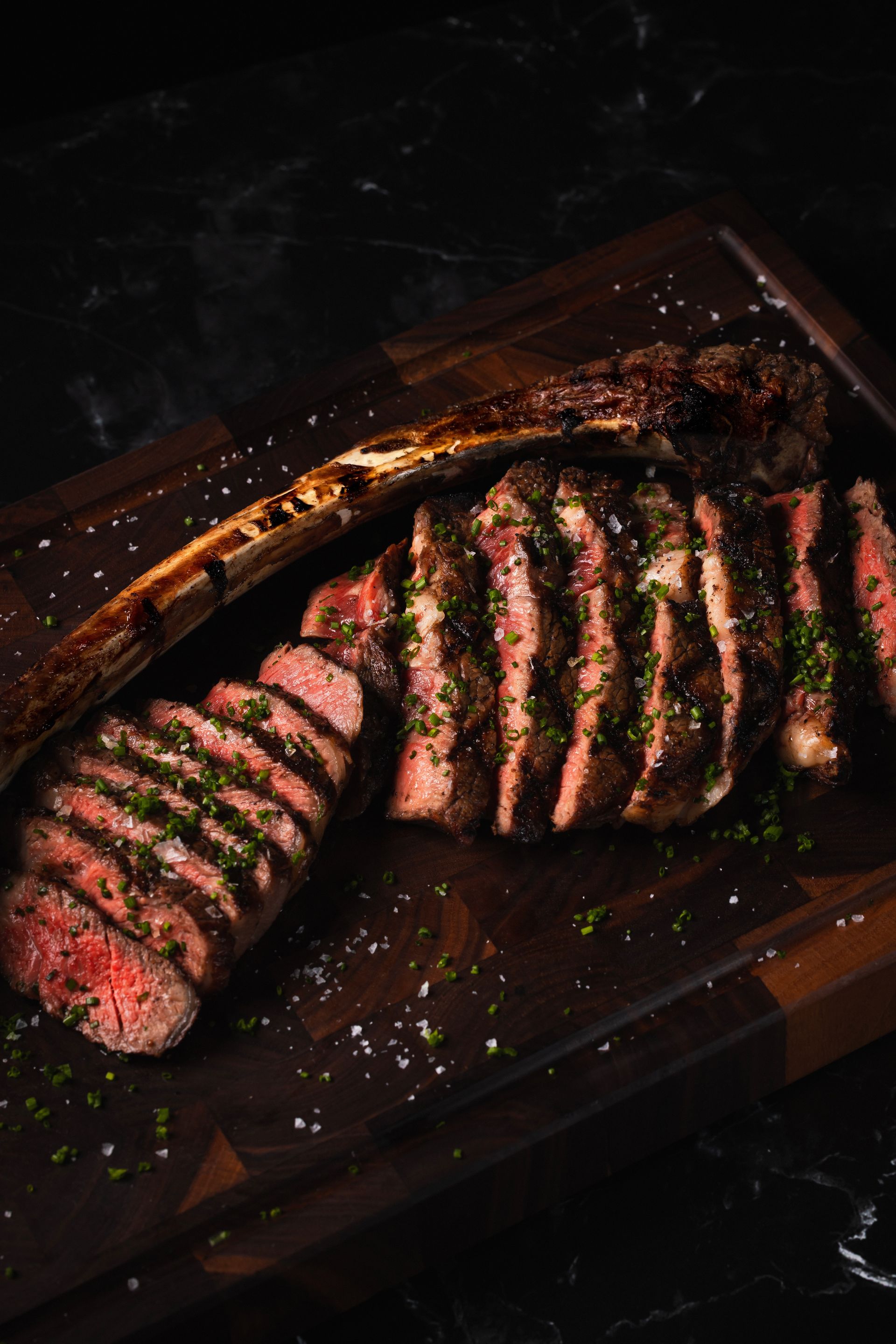 A large piece of meat is sitting on top of a wooden cutting board.