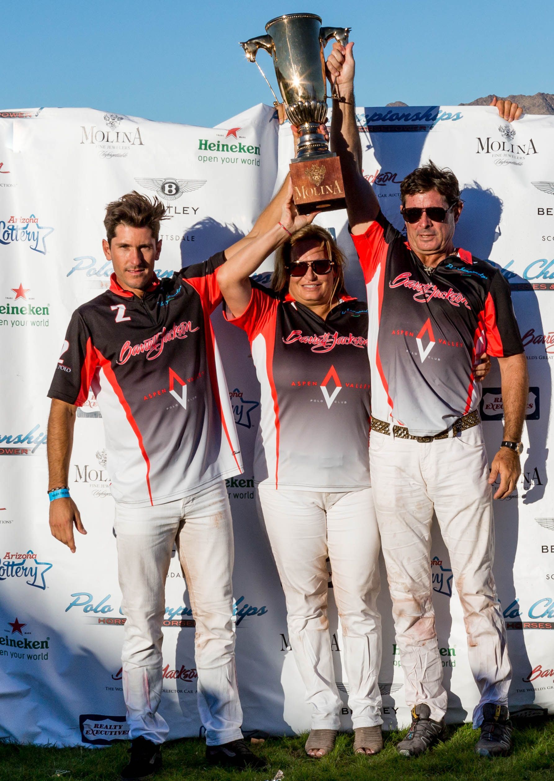 A group of people standing next to each other holding a trophy.