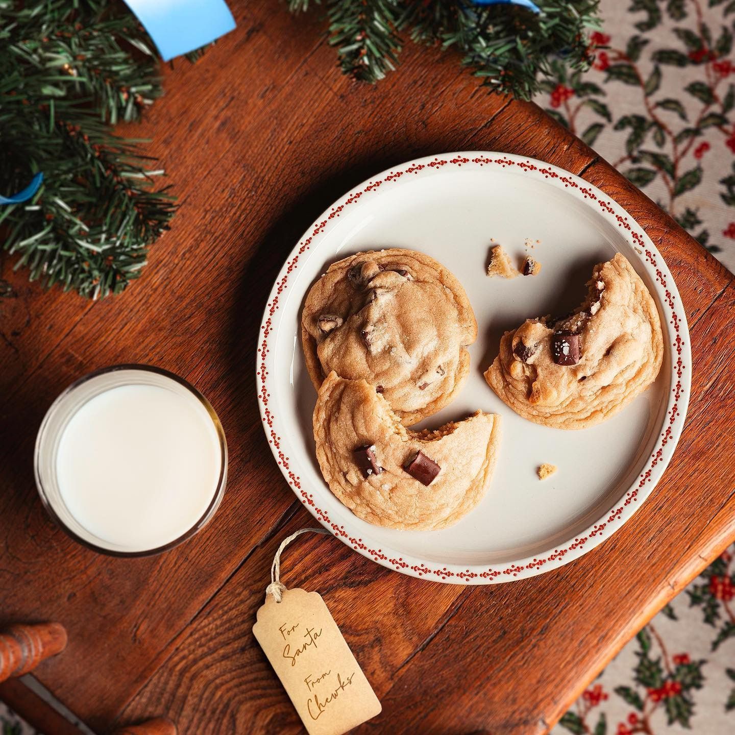 A plate of cookies and a glass of milk on a wooden table