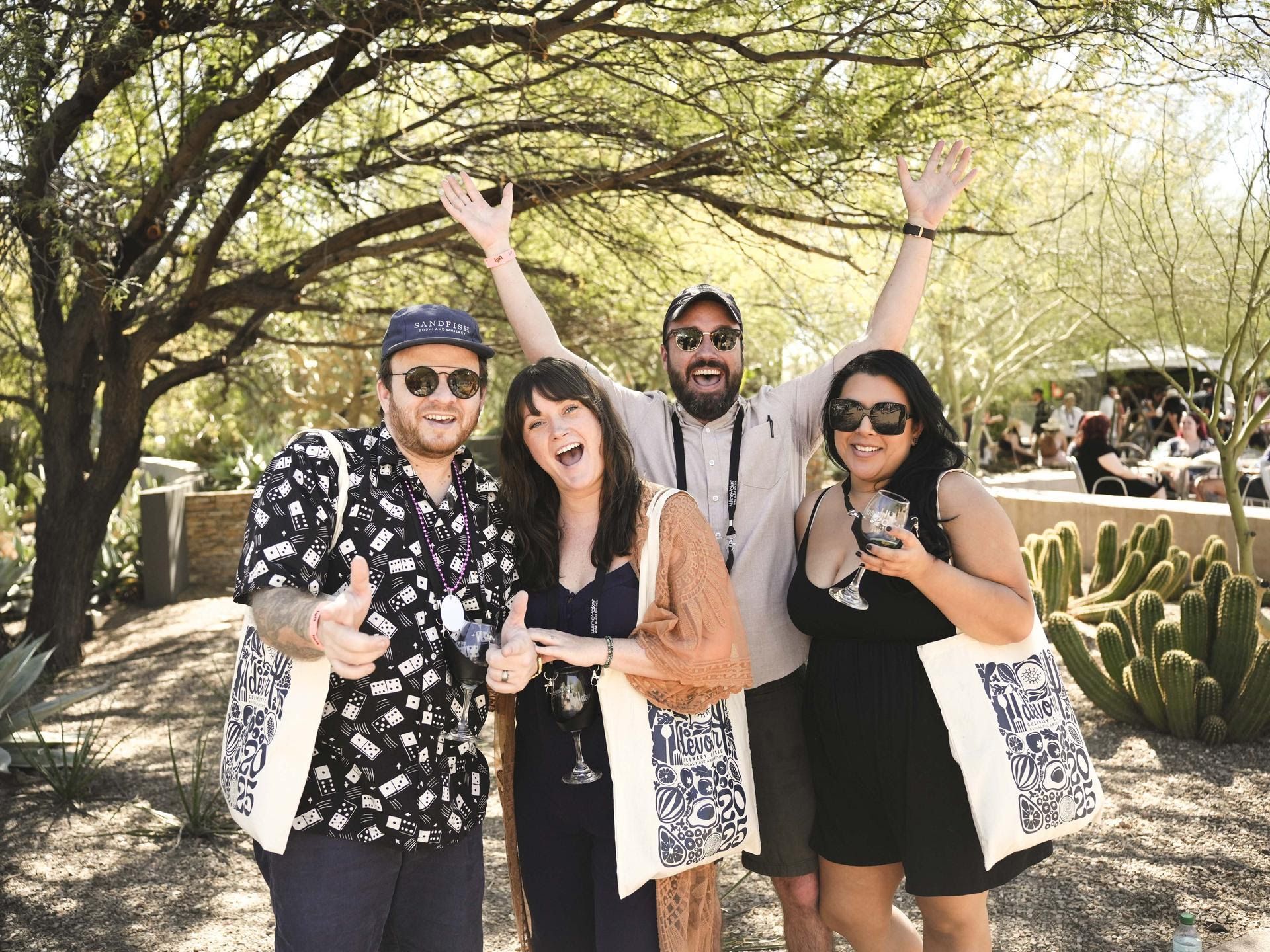 A group of people standing next to each other with their arms in the air.