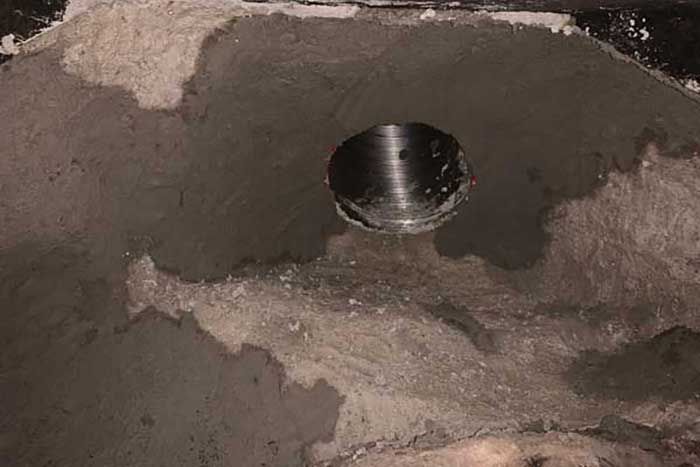 Hole in a gray, textured surface; possible construction or repair.