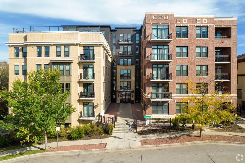 An aerial view of two apartment buildings next to each other on a sunny day.