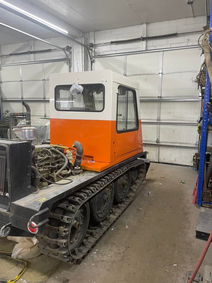 Orange and white tracked vehicle inside a garage.