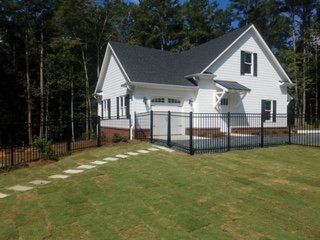 A white house with a black fence around it