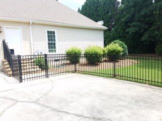 A white house with a black fence in front of it
