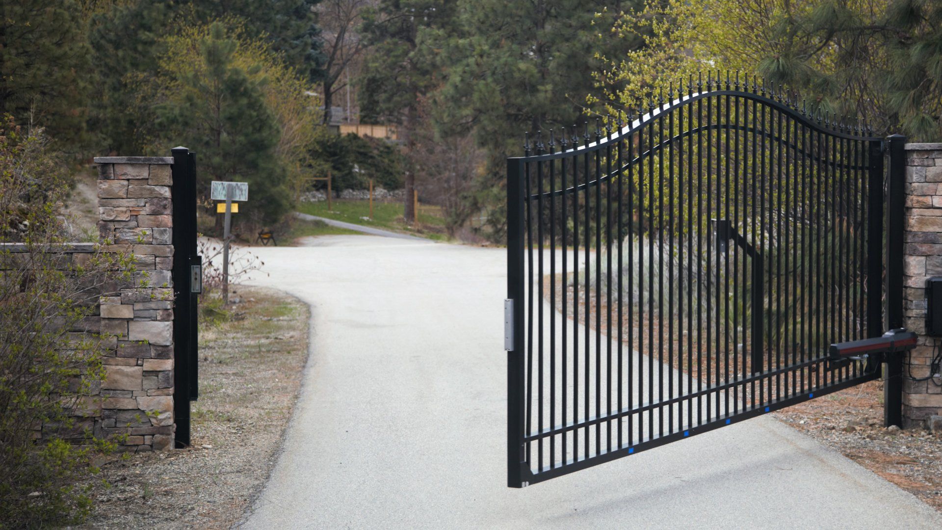 A black wrought iron gate in LaGrange Ga is open to a road.