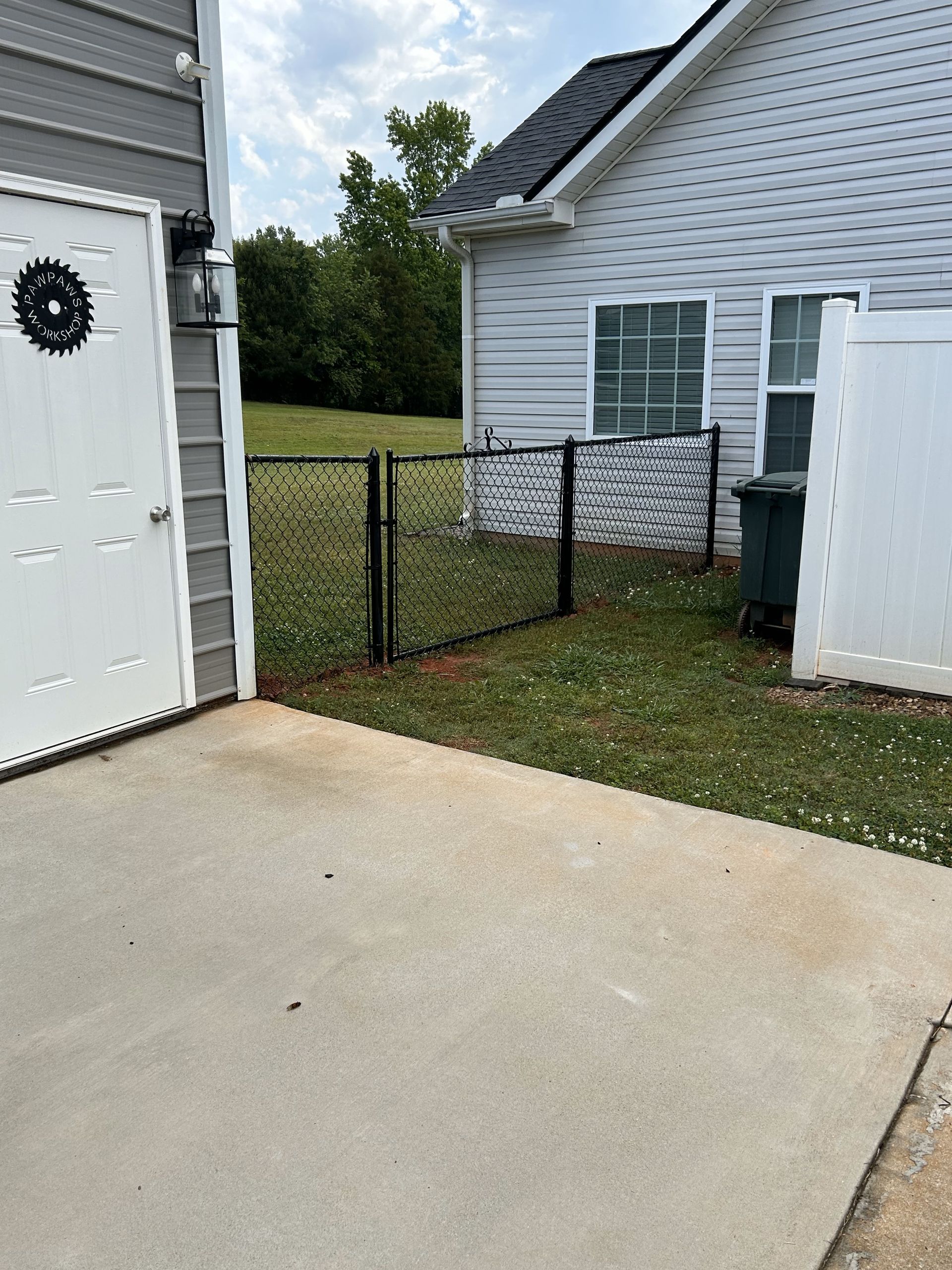 A white house with a chain link fence in front of it