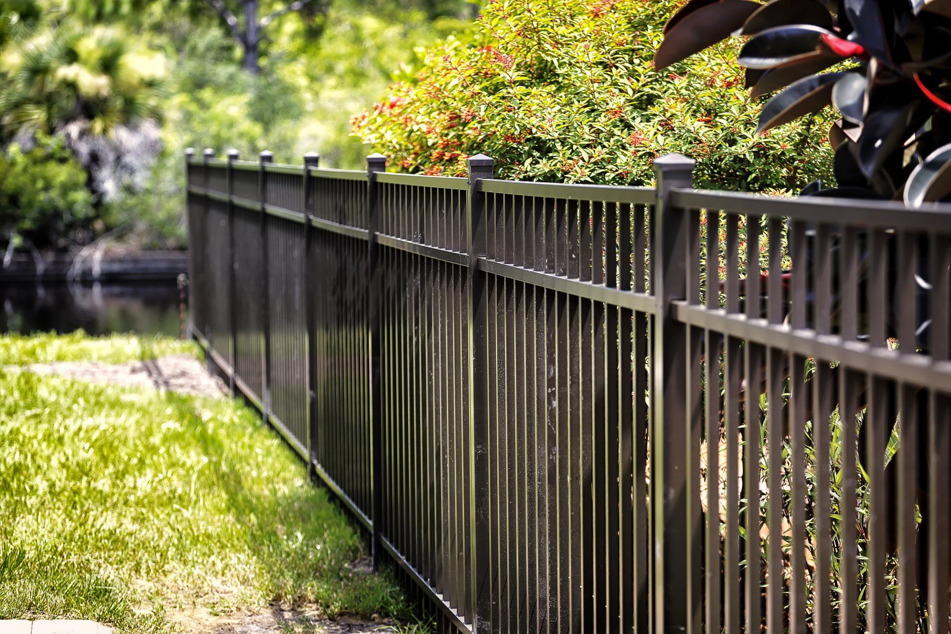 A long metal fence surrounds a lush green yard in LaGrange Ga.