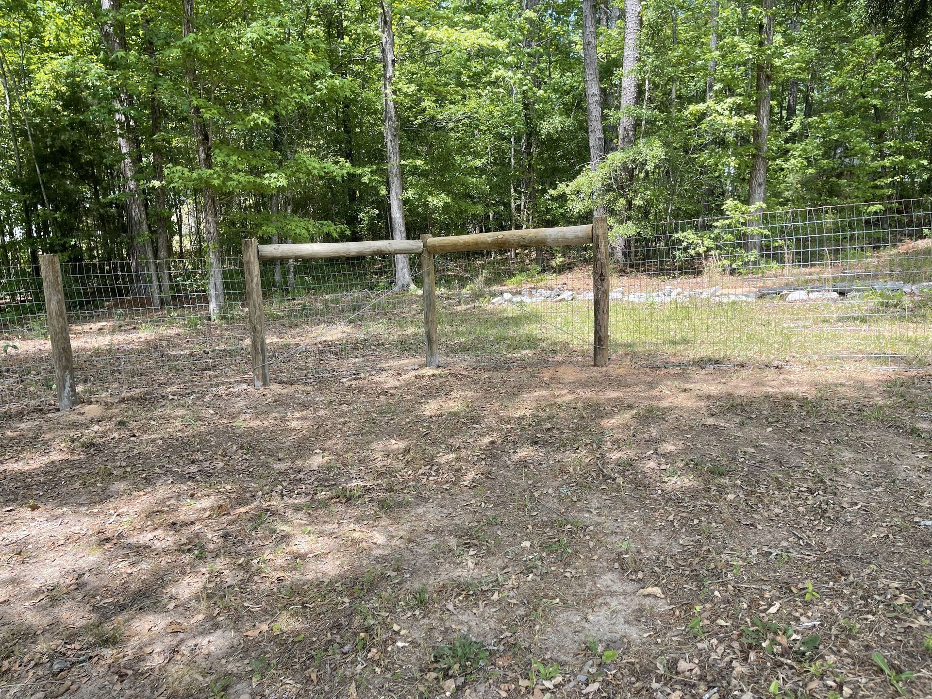 There is a wooden fence in the middle of the woods.