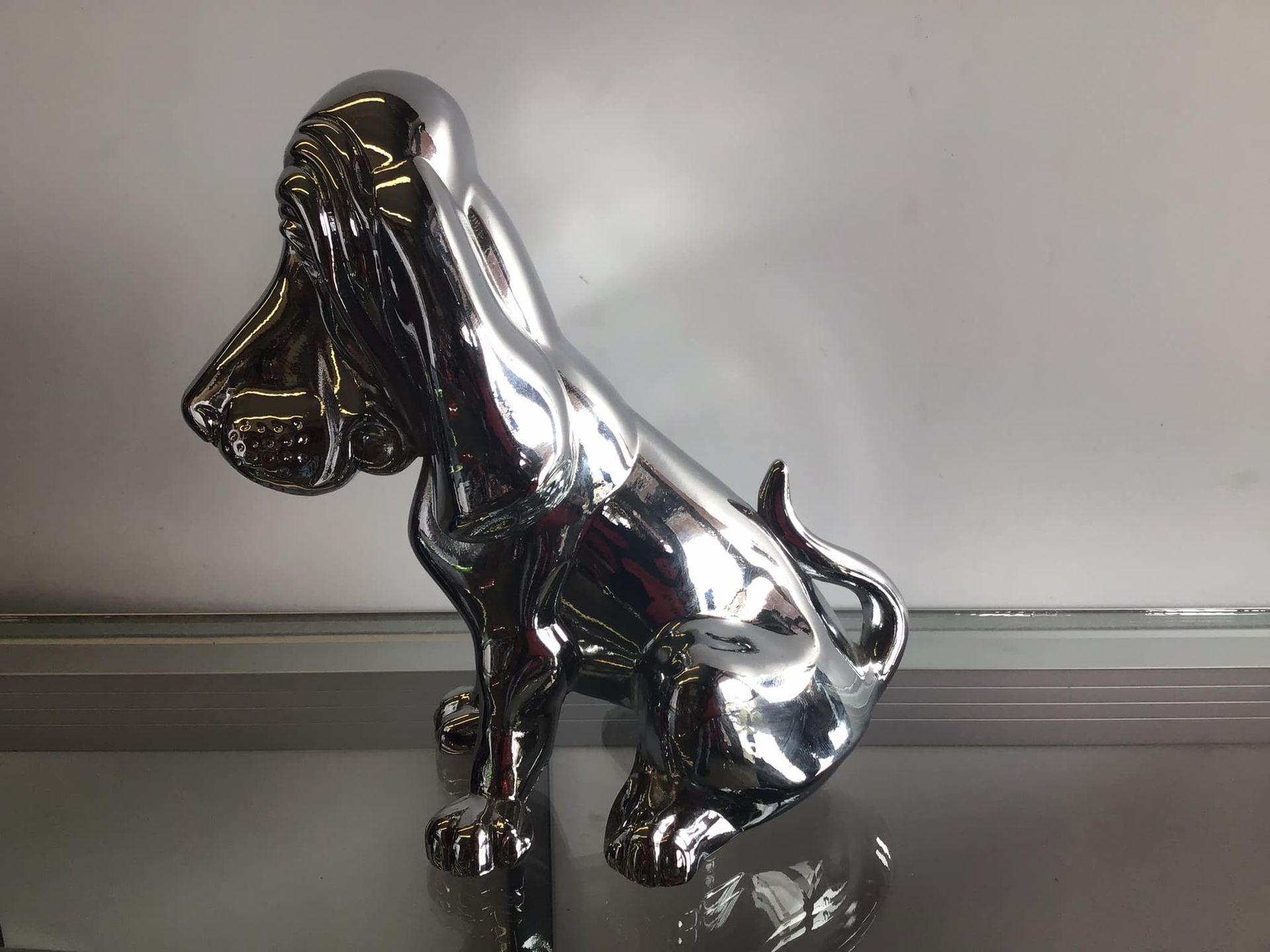 A chrome statue of a dog is sitting on a table