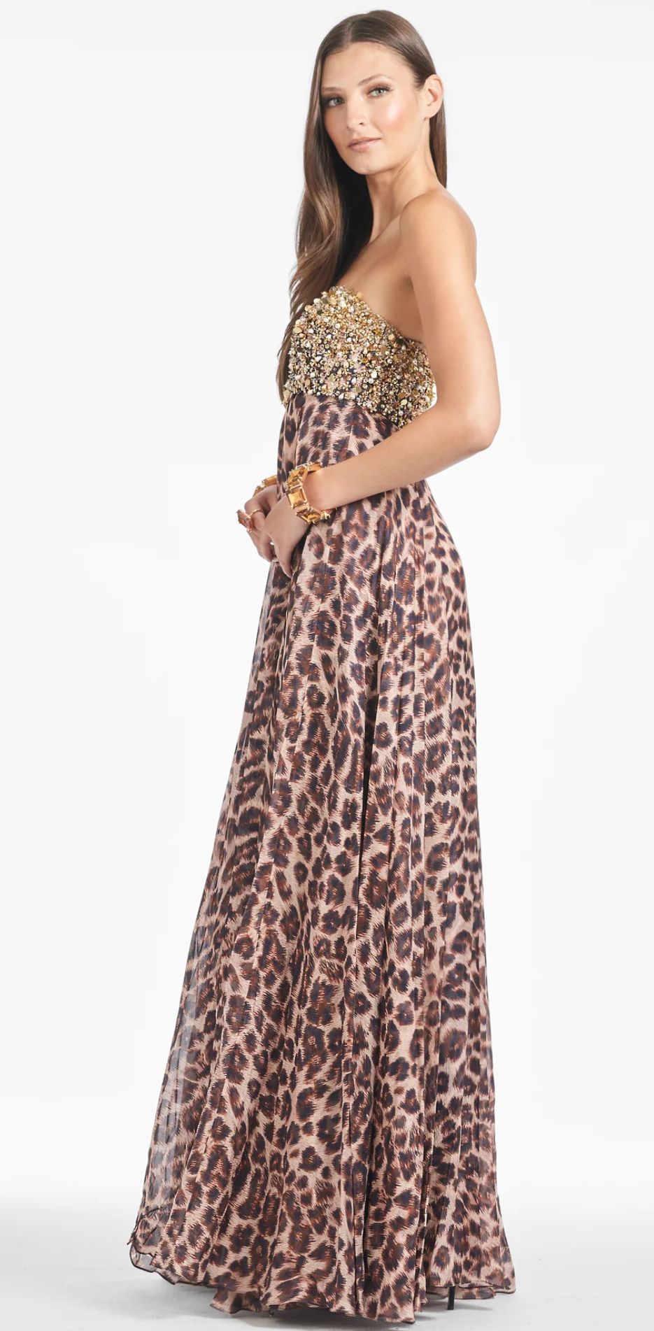 A woman in a black dress is sitting on a rock.