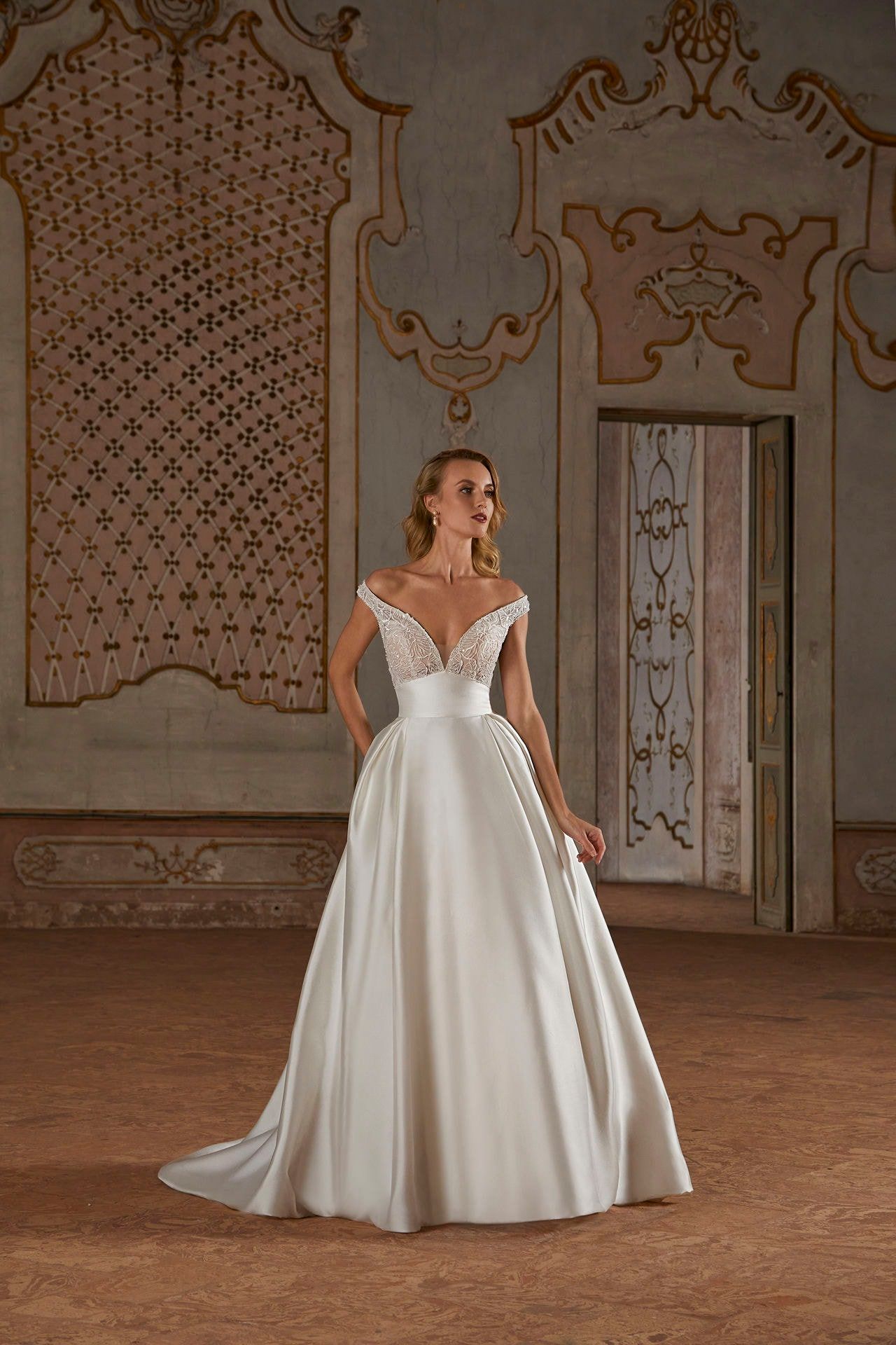 A woman in a white wedding dress is standing in a room.