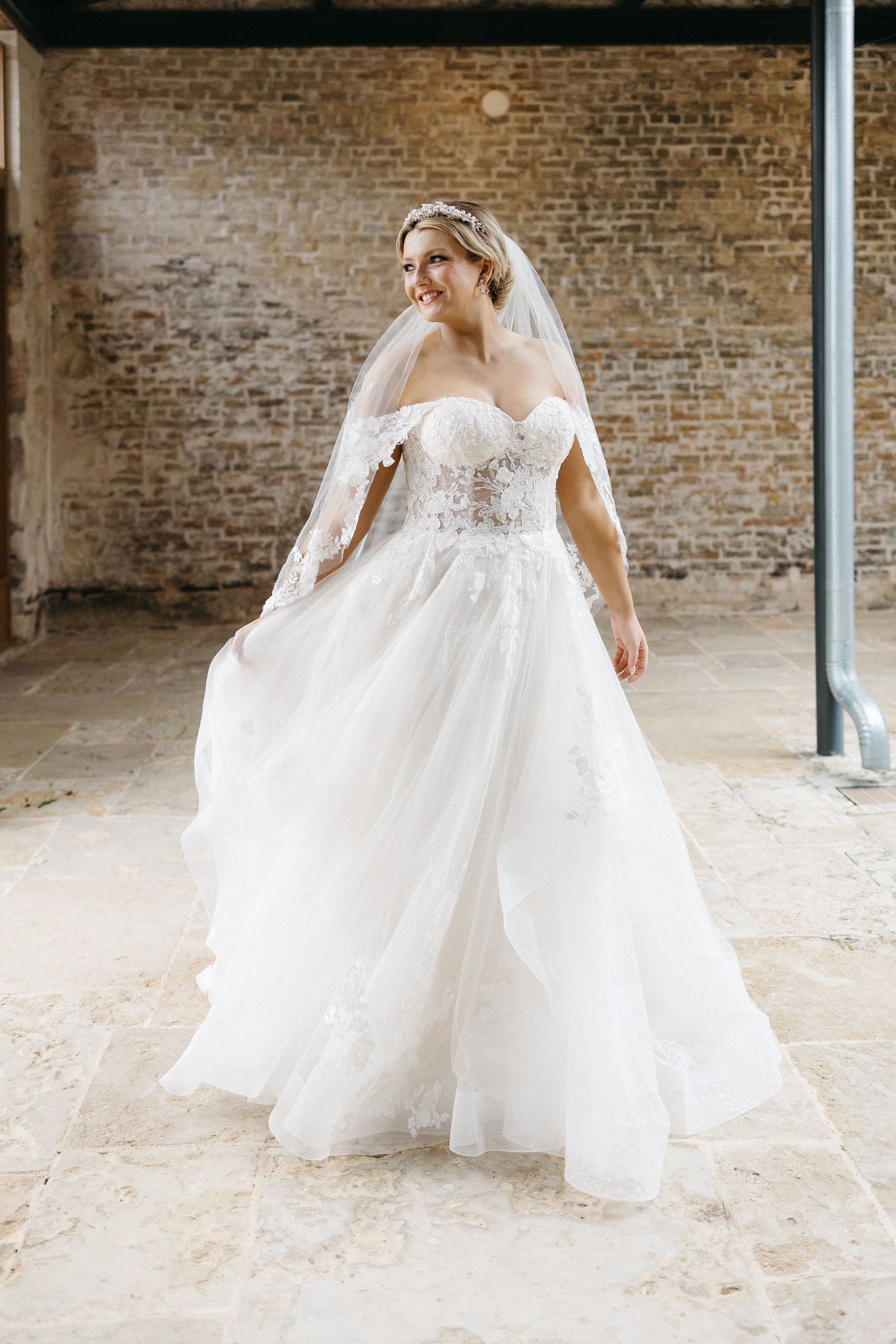A bride in a wedding dress is standing on a set of stairs holding a bouquet of flowers.