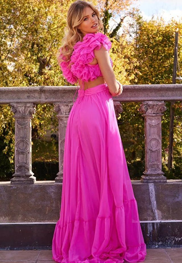 A woman in a pink dress is standing on a balcony.