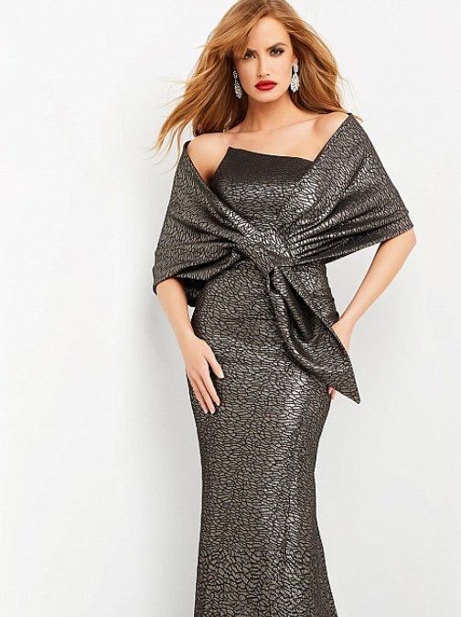 A woman is wearing a long black dress with a shawl around her shoulders.