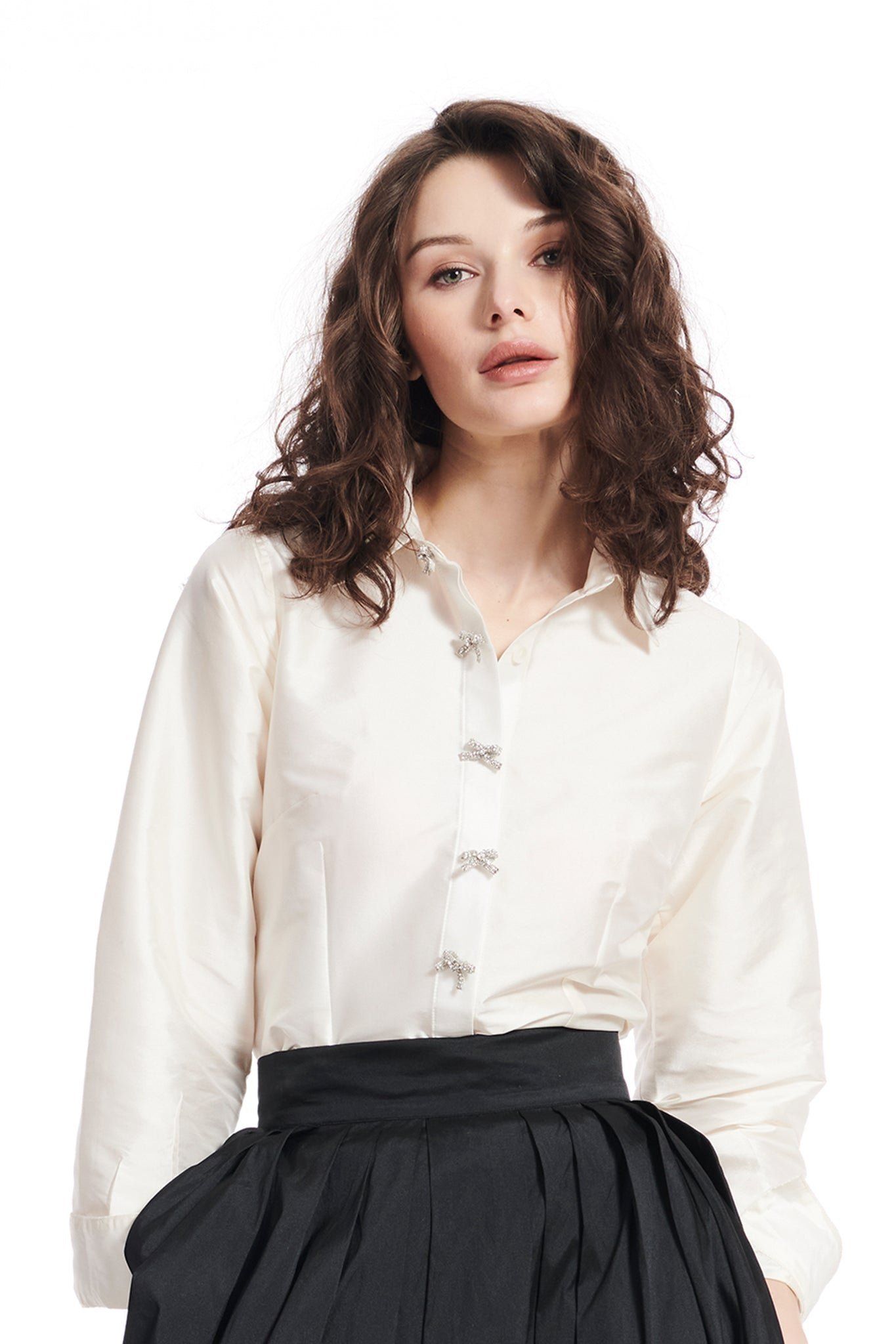 A woman is wearing a white shirt and a black skirt.