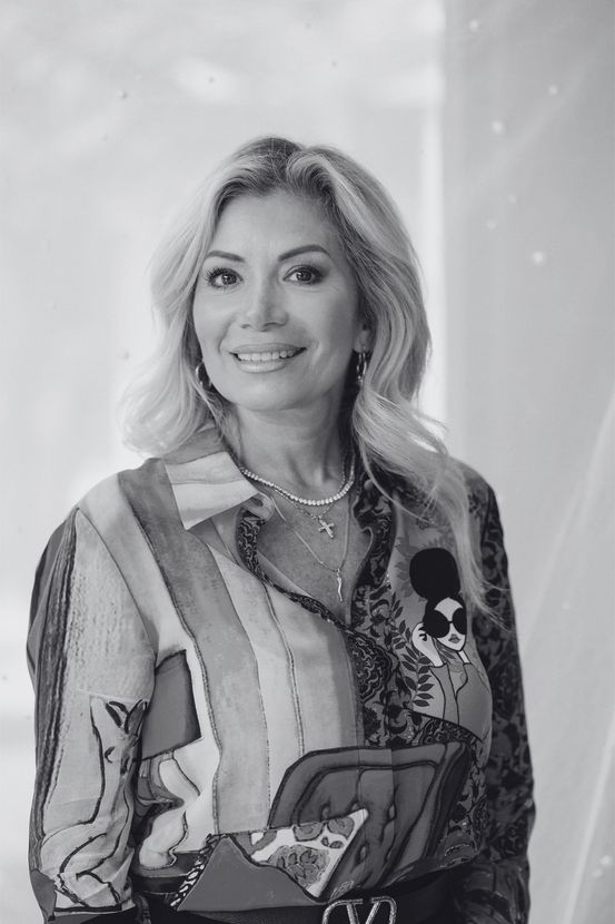The Boutique Owner is smiling in a black and white photo.