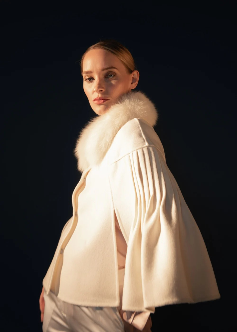 A woman wearing a wedding beige jacket 