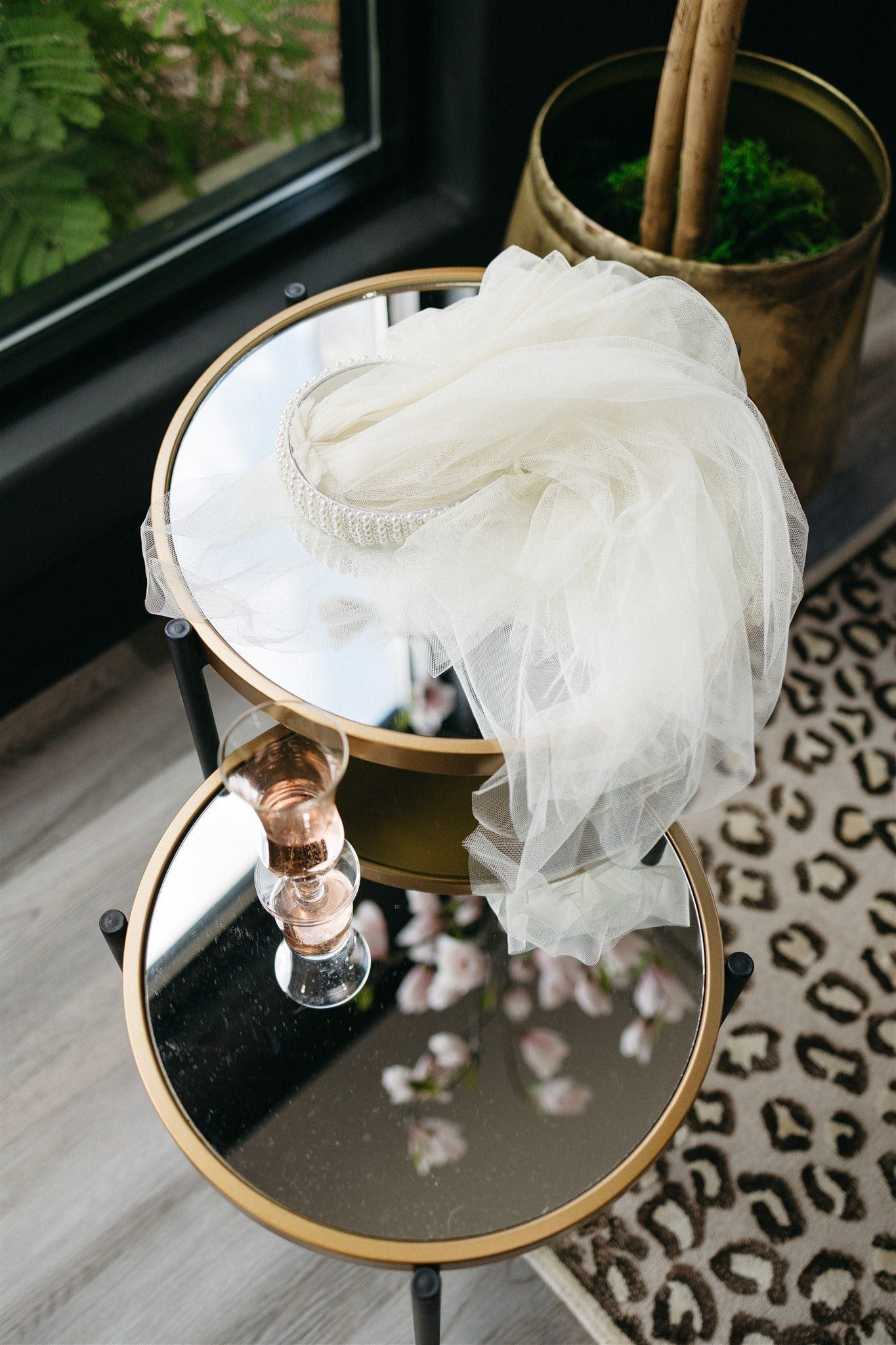 A table with a mirror on top of it and a plant in a pot.