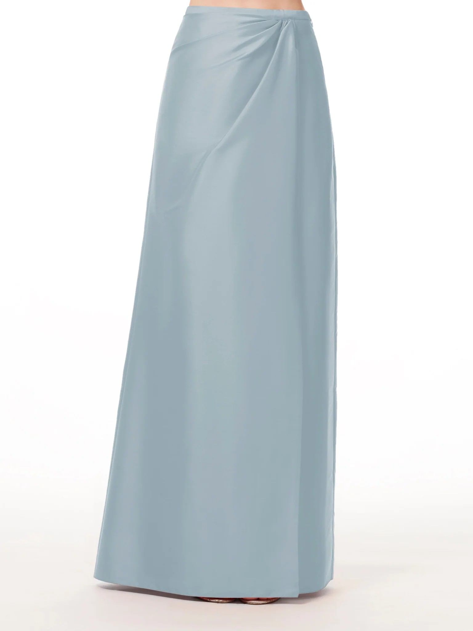 A woman is wearing a light blue long skirt.