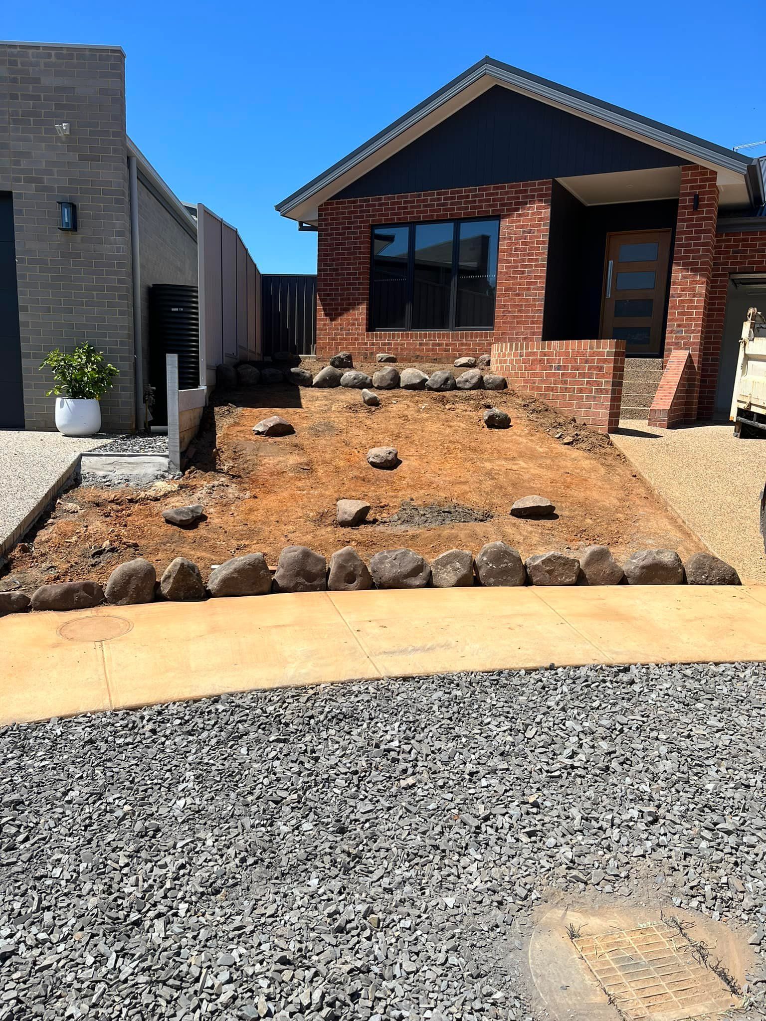 House Front With Exposed Dirt, Rock Border, and Gravel Driveway — Robbo's Hire In Thurgoona, NSW