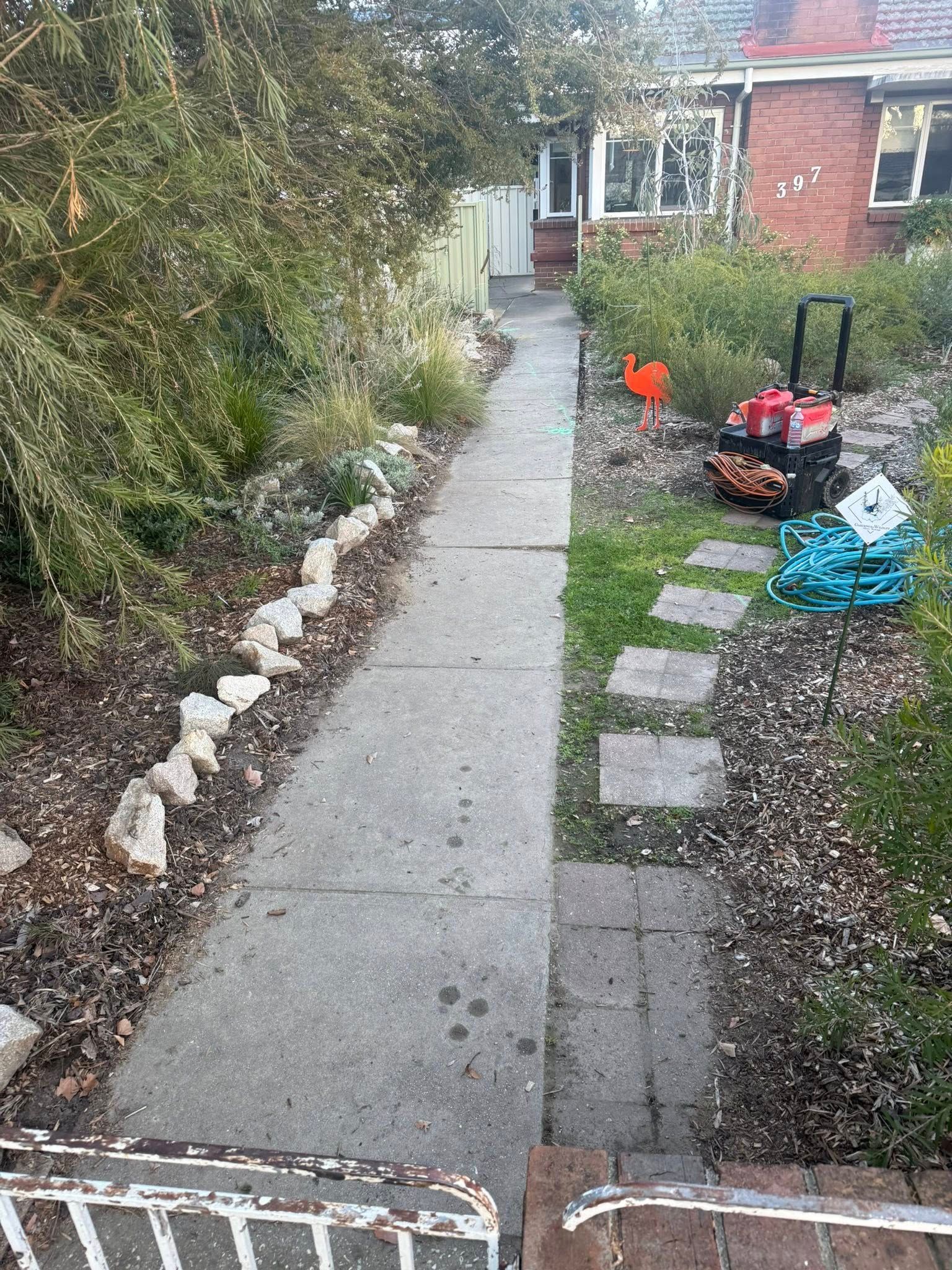 Concrete Path Leading to a House, Flanked by Gardens With Plants and Rocks — Robbo's Hire In Thurgoona, NSW
