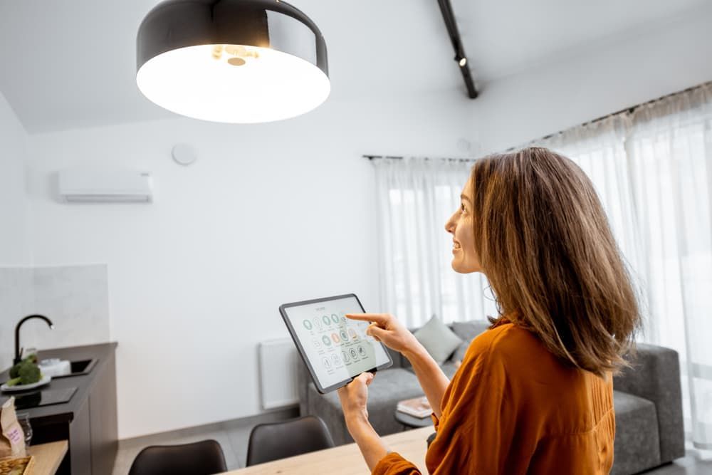Woman Controlling Home Light With Tablet - Smart Home Devices Newcastle, NSW