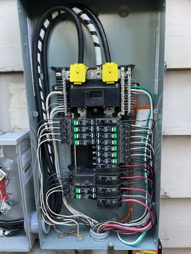 Electrical panel with numerous wires and circuit breakers.