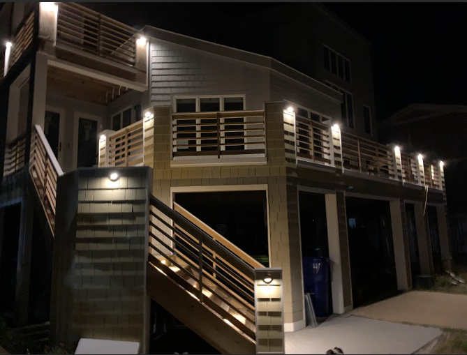 Night view of a multi-level house with lit balconies and staircases.
