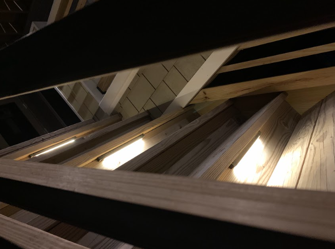 Wooden roof rafters, lit from below, with visible horizontal beams.
