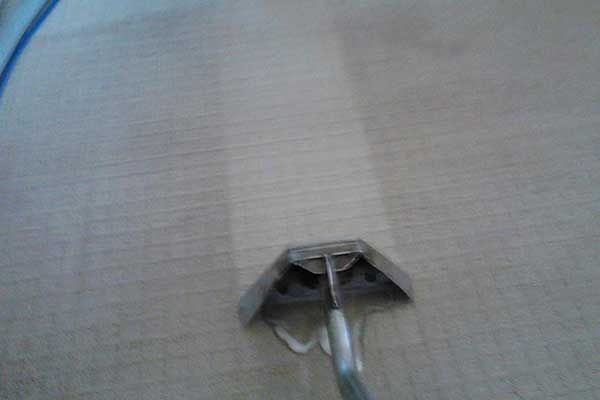 A Vacuum Cleaner Is Cleaning A Carpet In A Room — Carpet Cleaning in Goonellabah, NSW