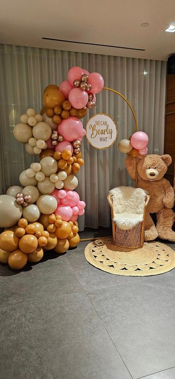 A room decorated with balloons and a teddy bear.