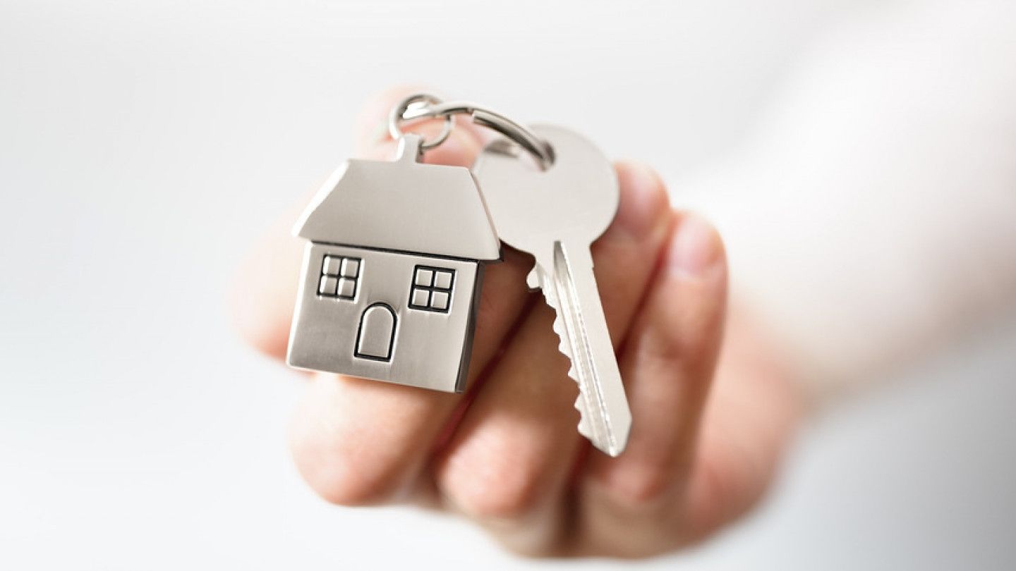 Holding House Keys On House Structure